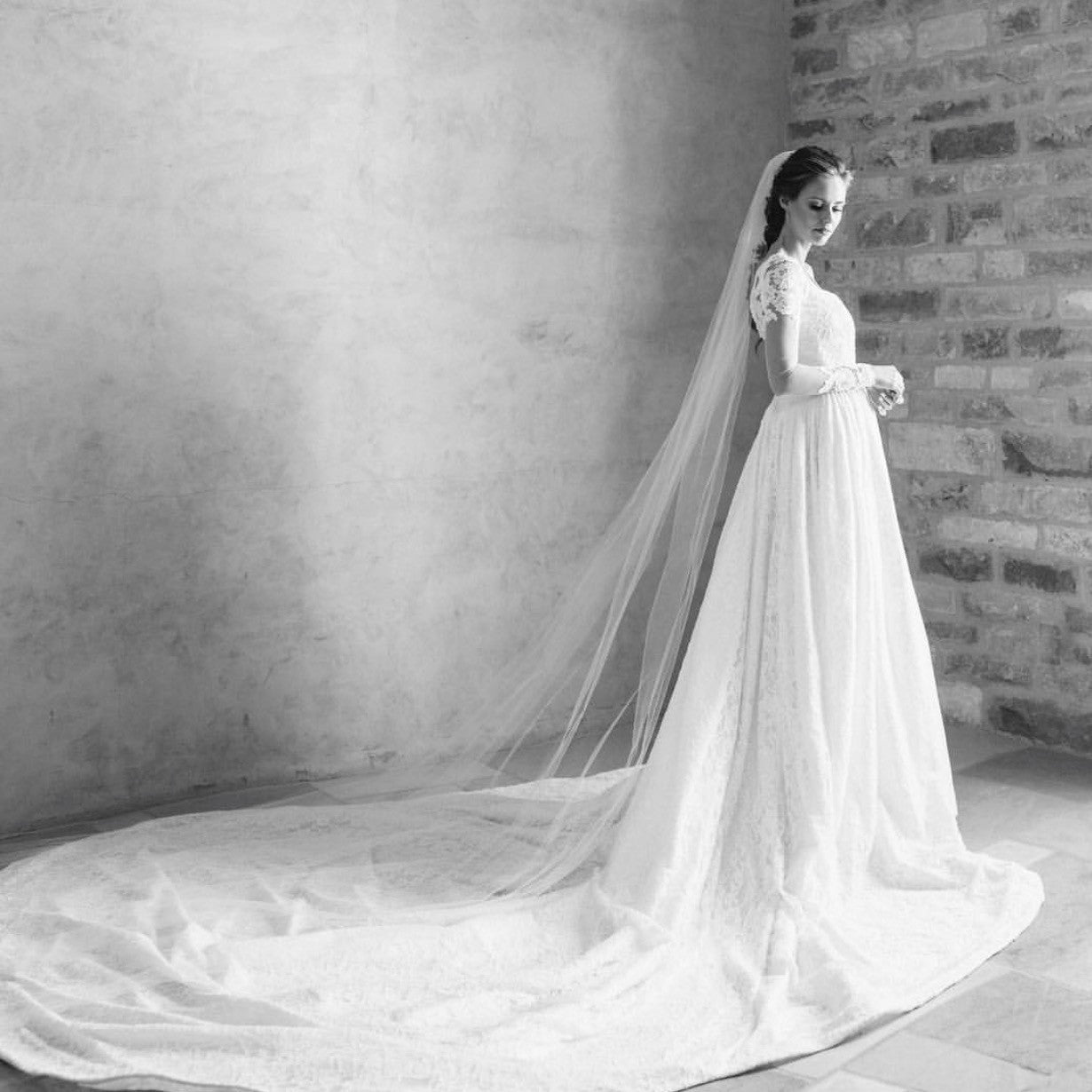 Bride Alyssa Campanella poses in her custom Lauren Elaine Bridal wedding dress with cathedral train and lace illusion sleeves at Sunstone Villa in Santa Ynez