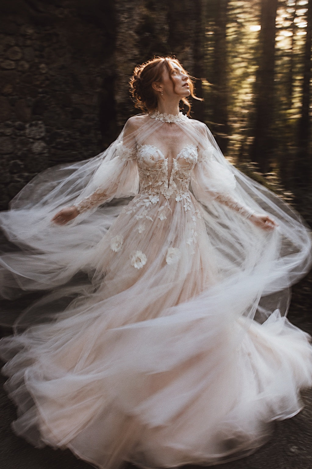 Arrowyn ethereal bridal gown with illusion corset and flowing tulle cape in motion.