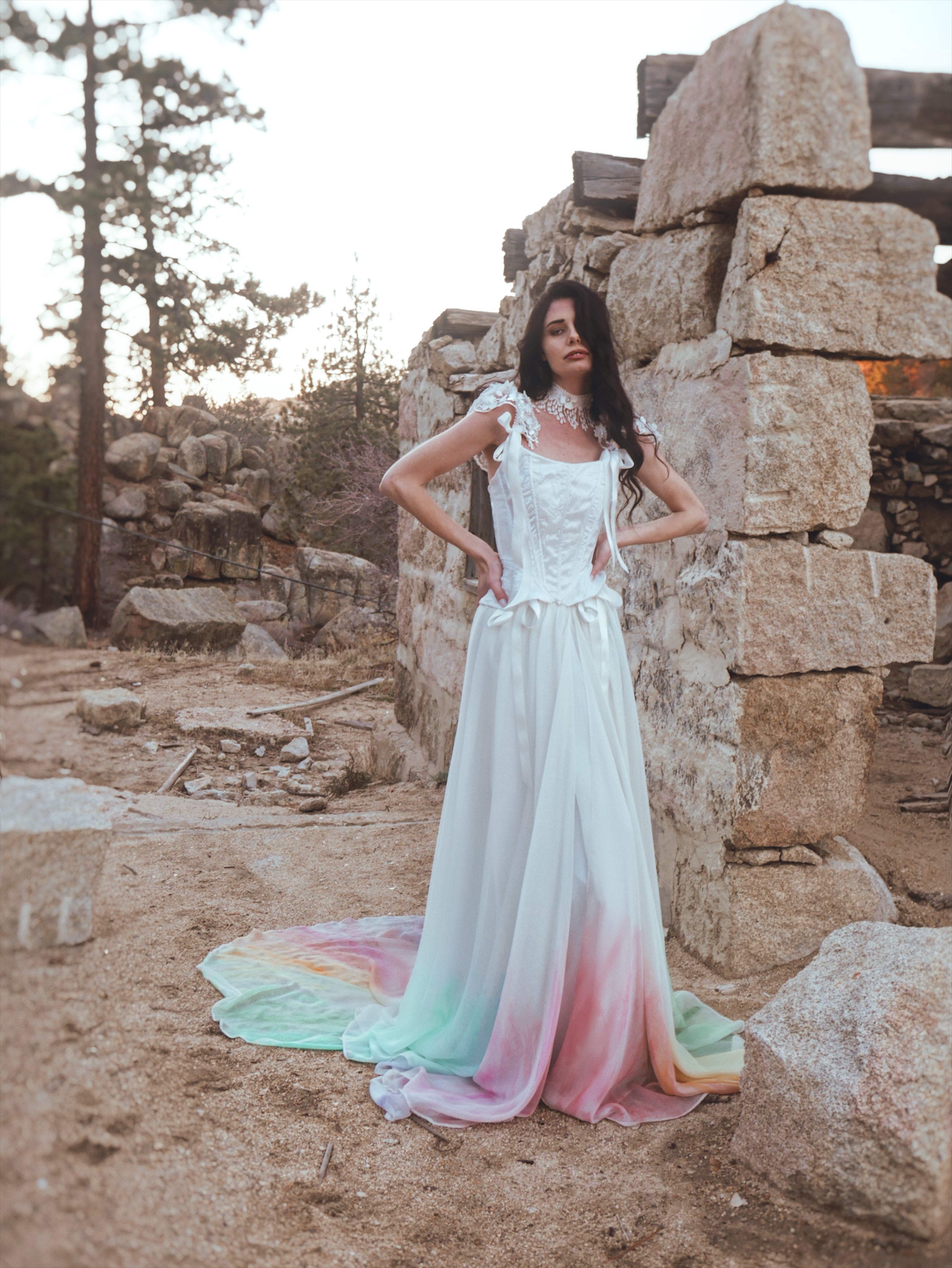 White corset bridal bodice with exposed boning and basque waist, worn with a flowing bridal skirt