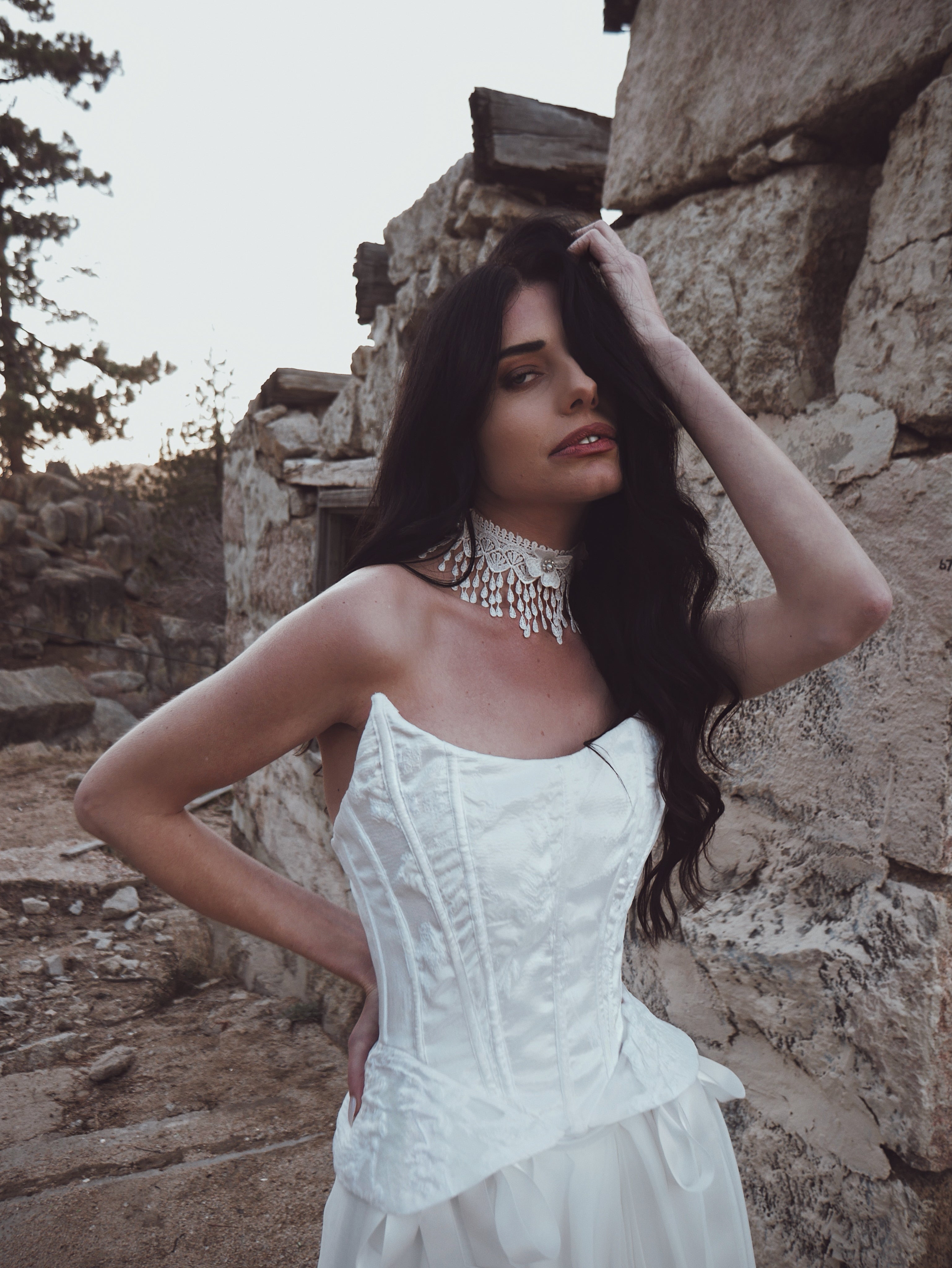 Close-up of floral brocade bridal corset featuring swoop neckline, exposed boning, and peplum hem