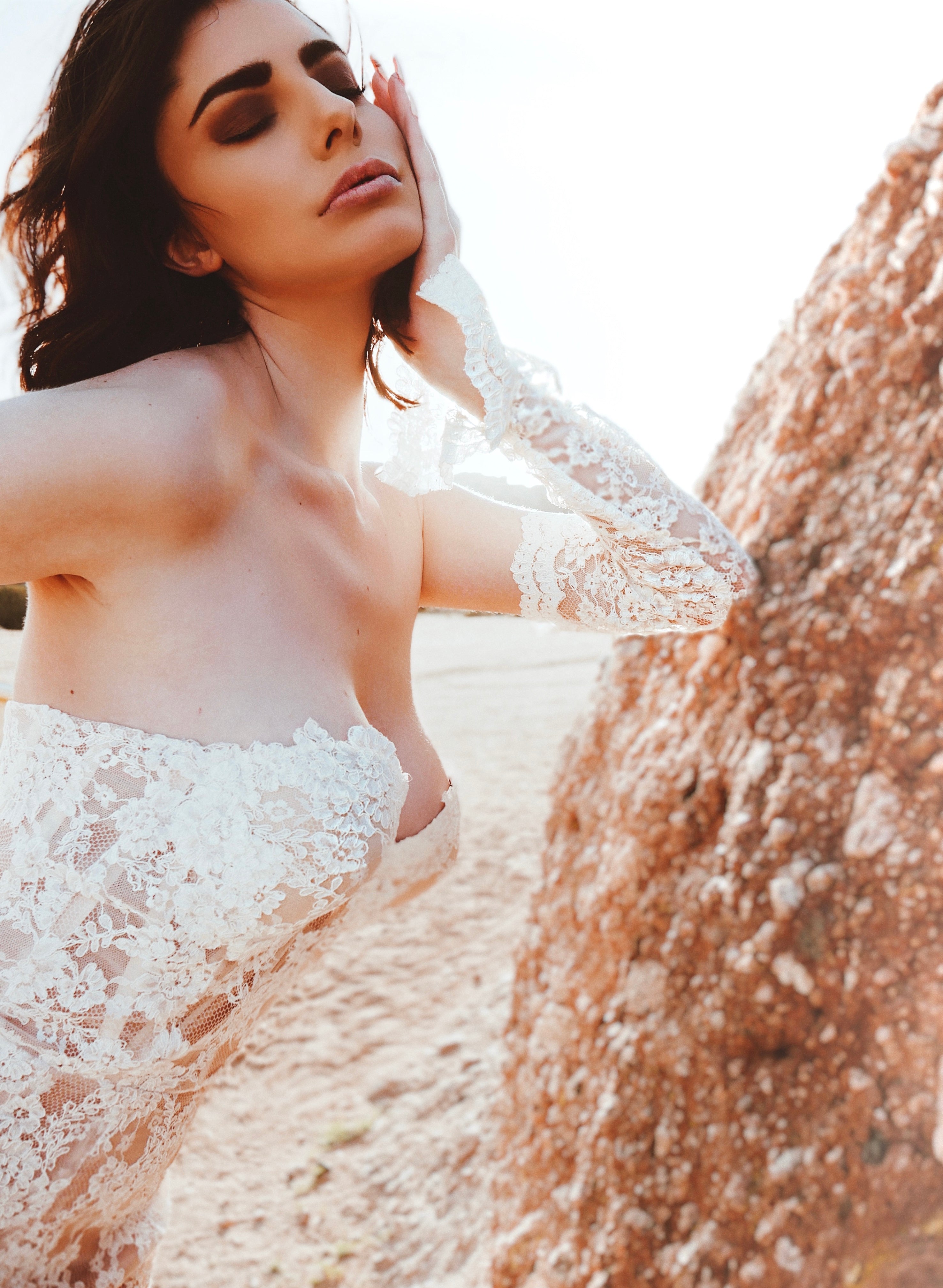 Editorial close-up of detachable lace wedding sleeves with sunlight flare