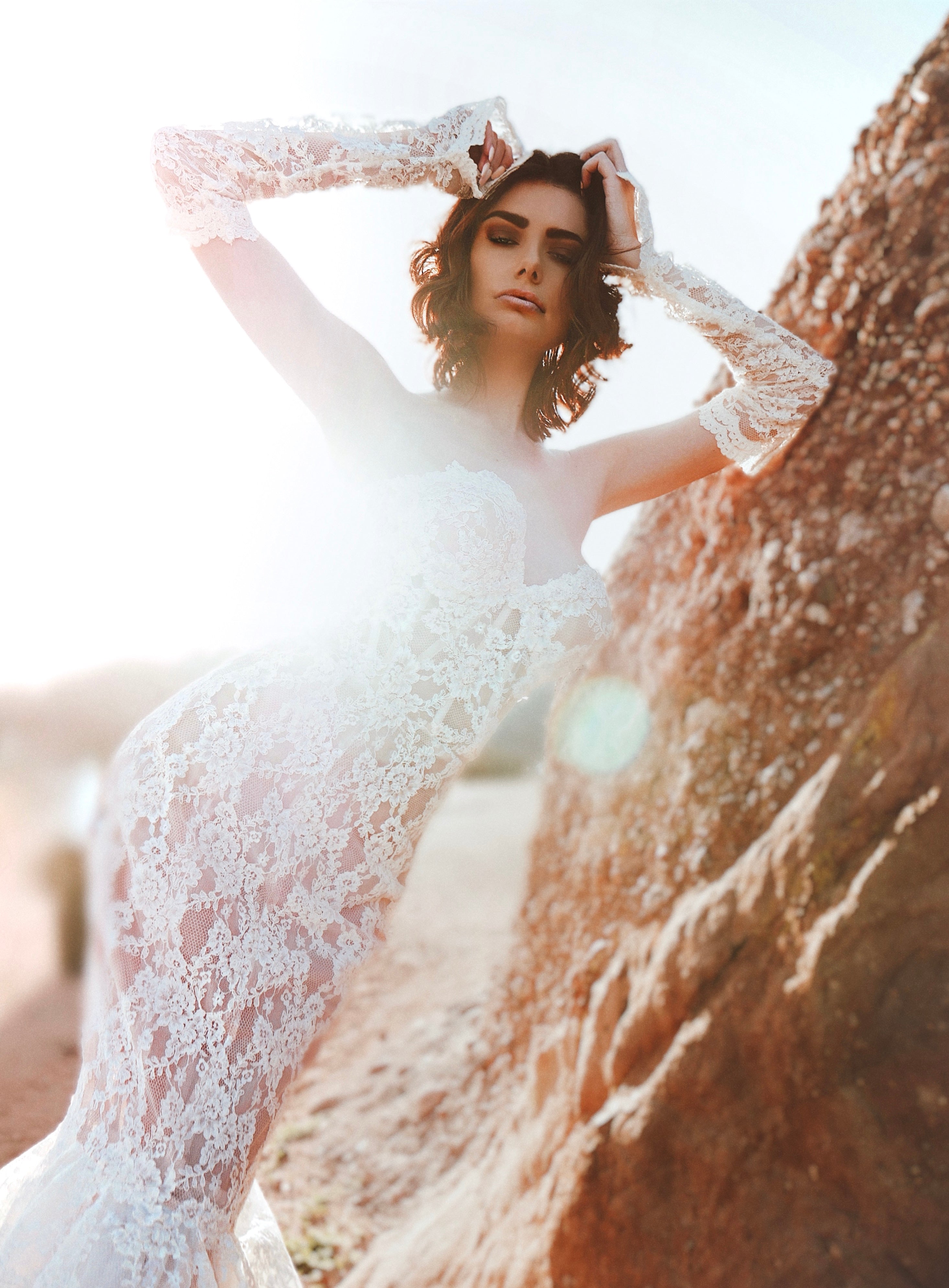 Full length view of a model wearing detachable lace glove bridal sleeves in sunlight