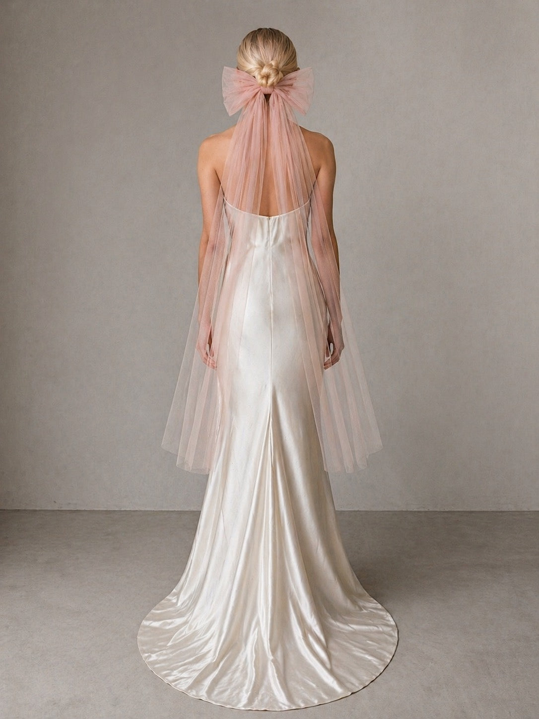 A bride wears a blush oversized tulle bow wedding veil - back view dolly bridal veil