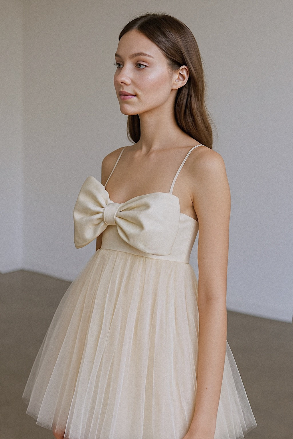 Side view of Dolly bridal mini with oversized satin bow, empire waist, and delicate tulle skirt
