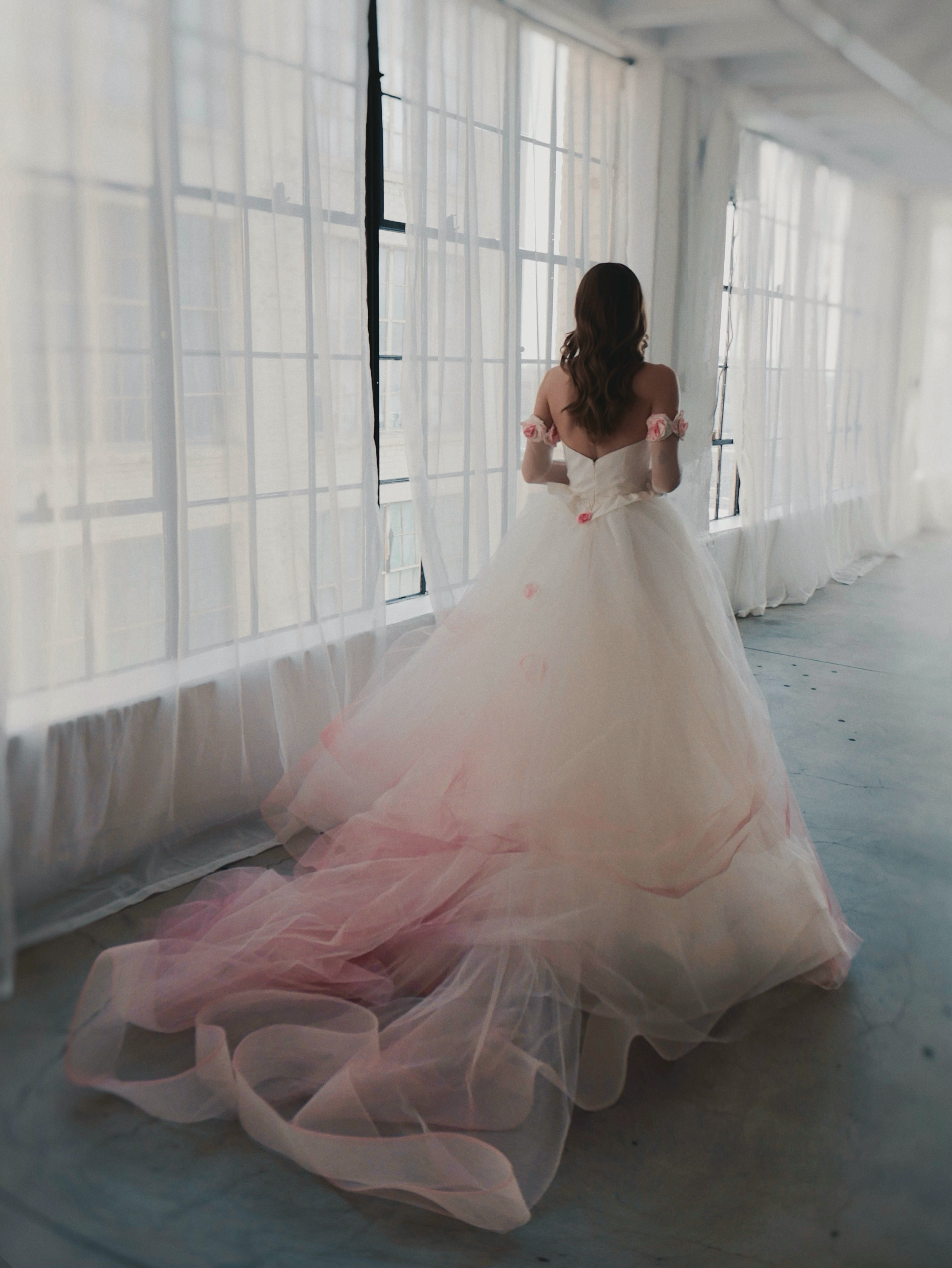 Back shot of model walking in strapless bustier blush ombre wedding dress