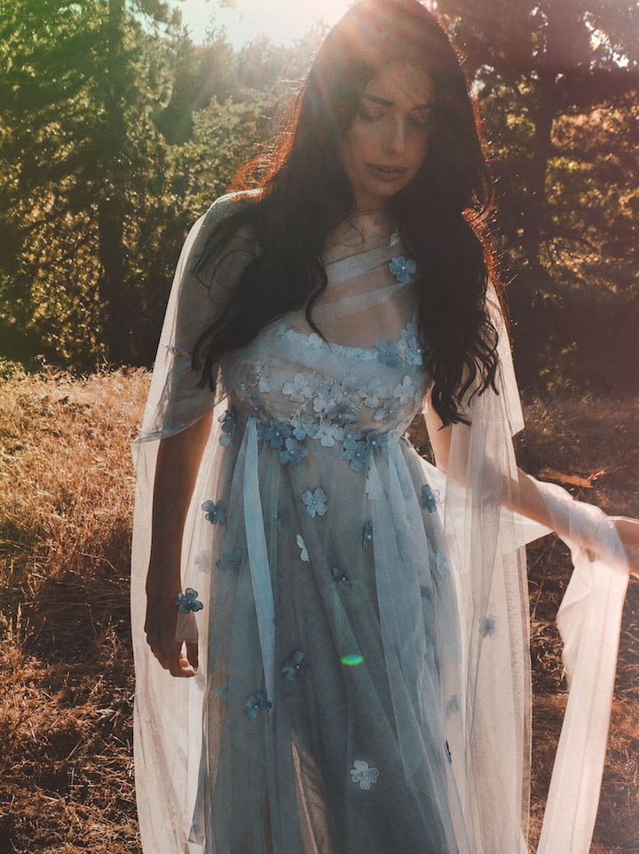 Florêve ethereal floral wedding dress with blue wildflower appliqués and sheer illusion net cape
