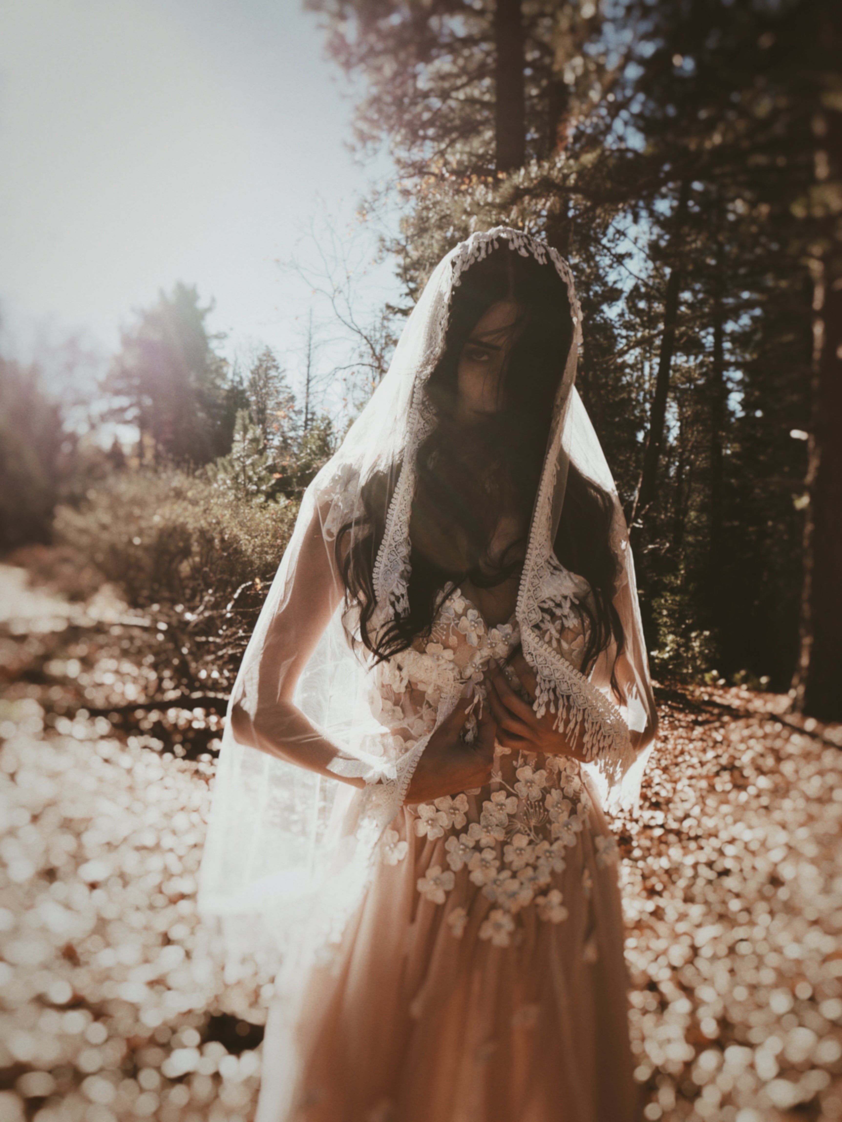 Bohemian crochet wedding veil with soft fringe trim, styled for an ethereal forest wedding aesthetic