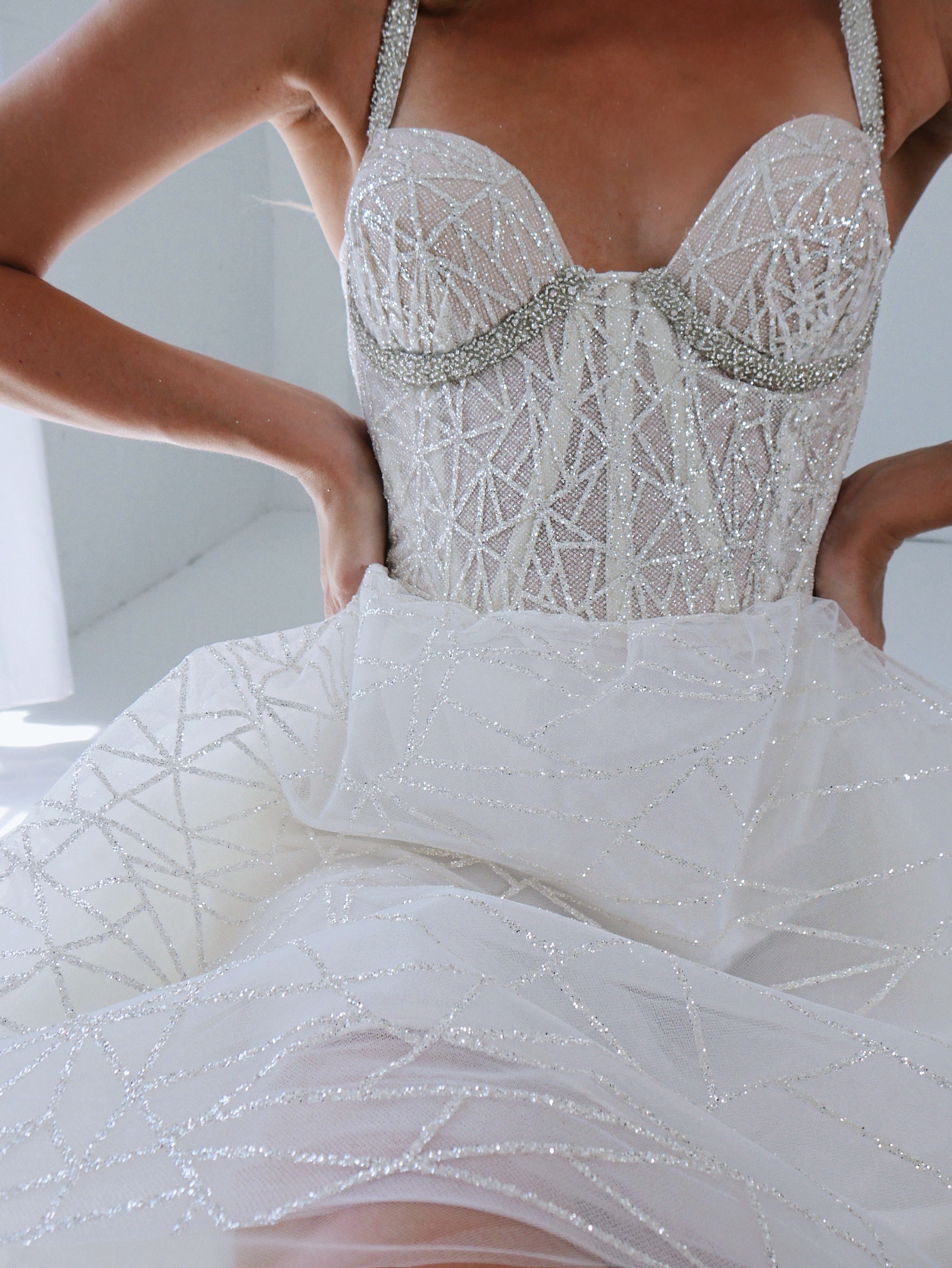 Detail image of a sparkling glitter mini wedding dress with bustier bodice