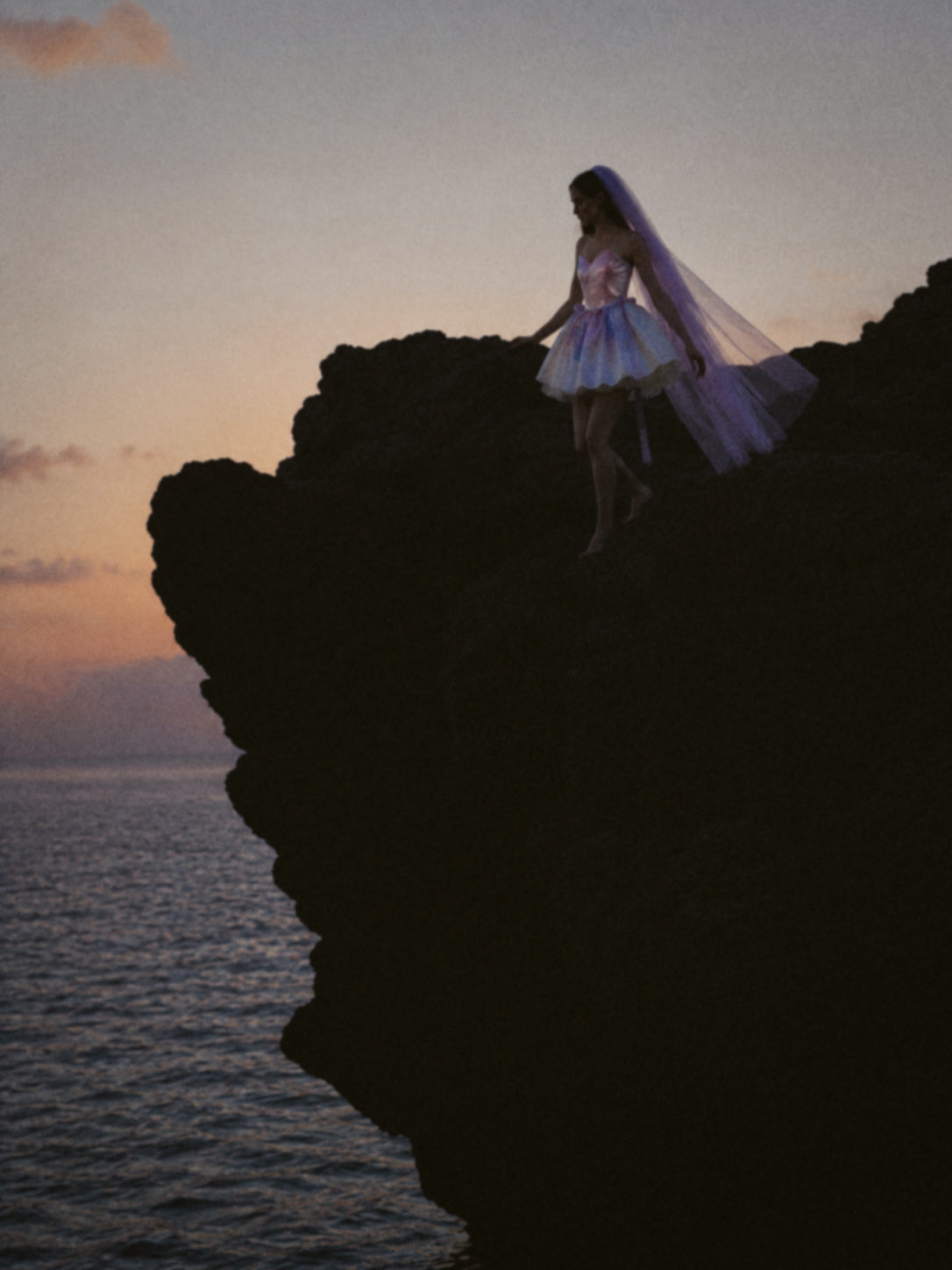 Moondreamer Mini wedding dress editorial featuring a colorful bridal mini dress on dramatic seaside cliffs at sunset