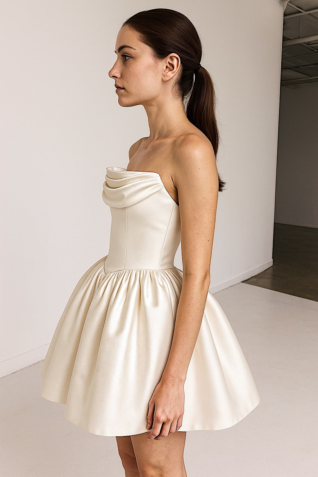Side view of Roxie satin mini bridal gown with basque waist and crumb catcher bodice