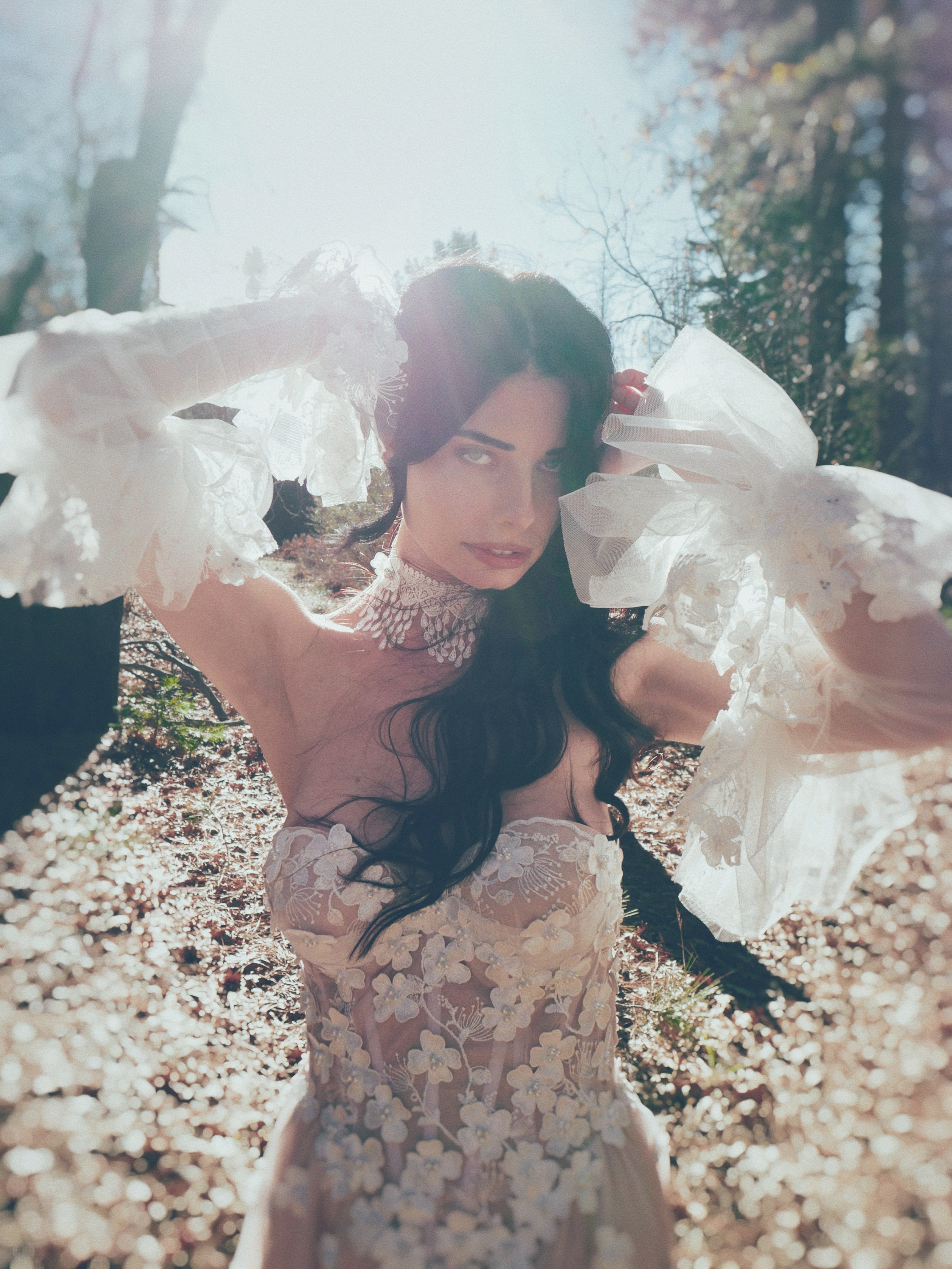 Valen ethereal A-line wedding dress with basque waist, exposed corset bodice, and dimensional floral appliqués in a romantic forest setting