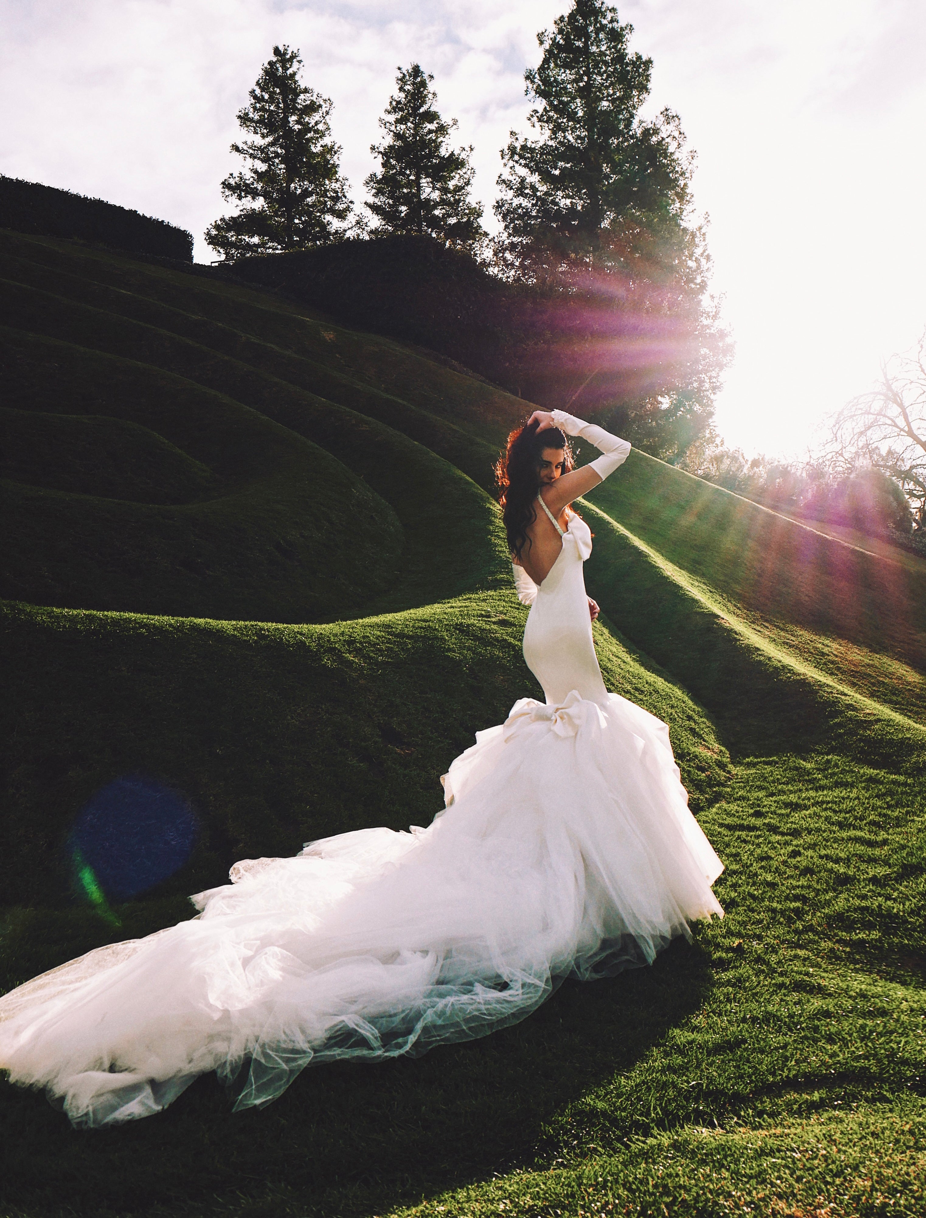 Dramatic mermaid wedding dress with tulle skirt and satin glove bridal sleeves.