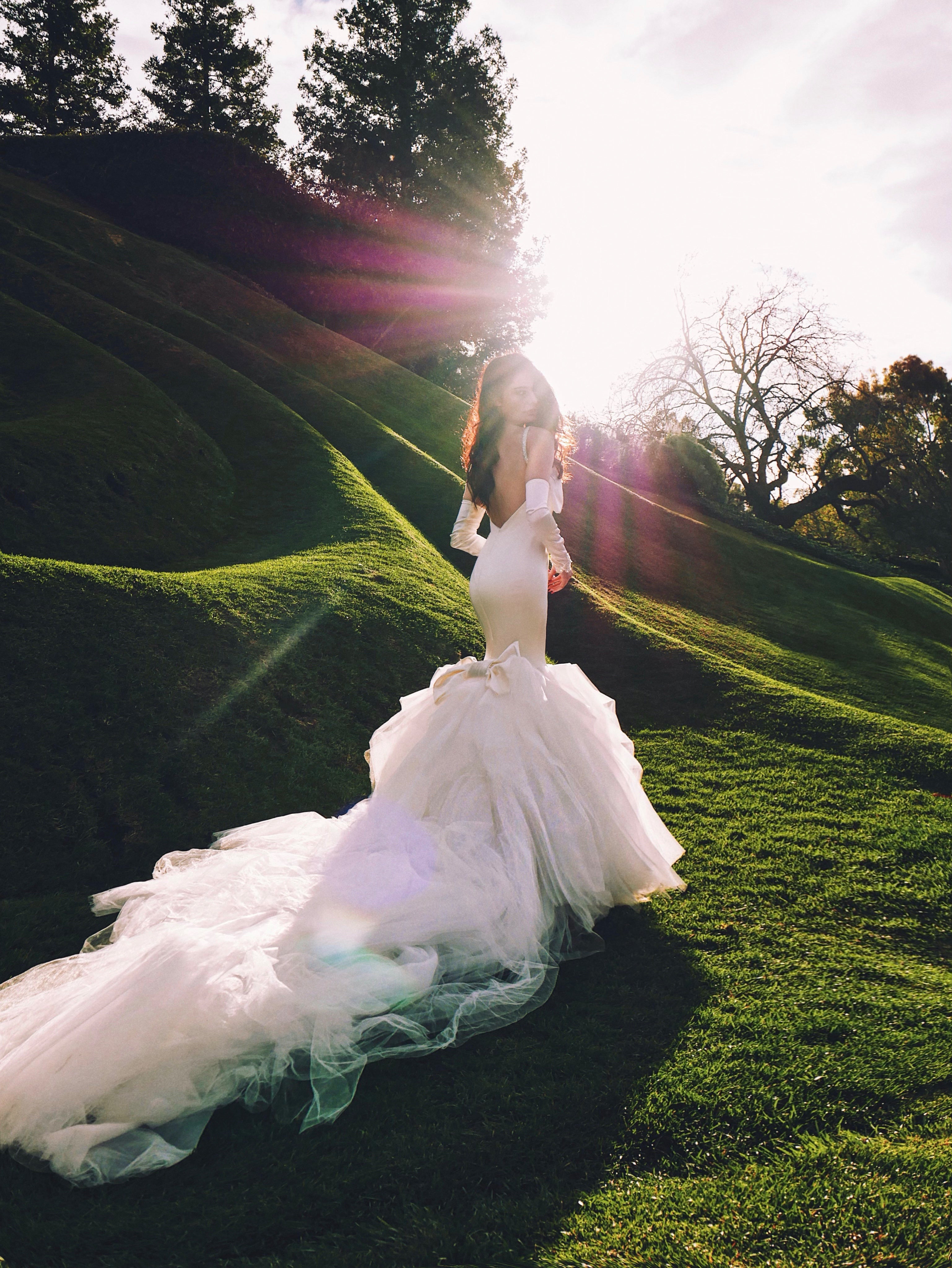 Dramatic mermaid wedding dress with tulle skirt and satin glove bridal sleeves.