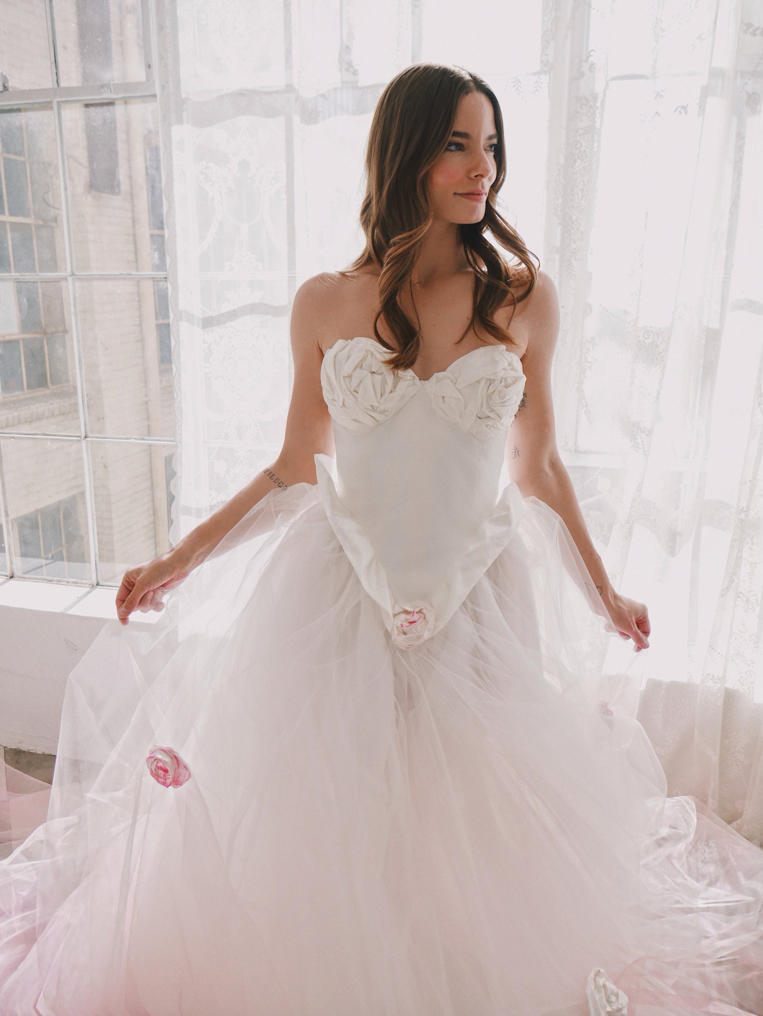 Bride holding skirt of Basque waist wedding dress