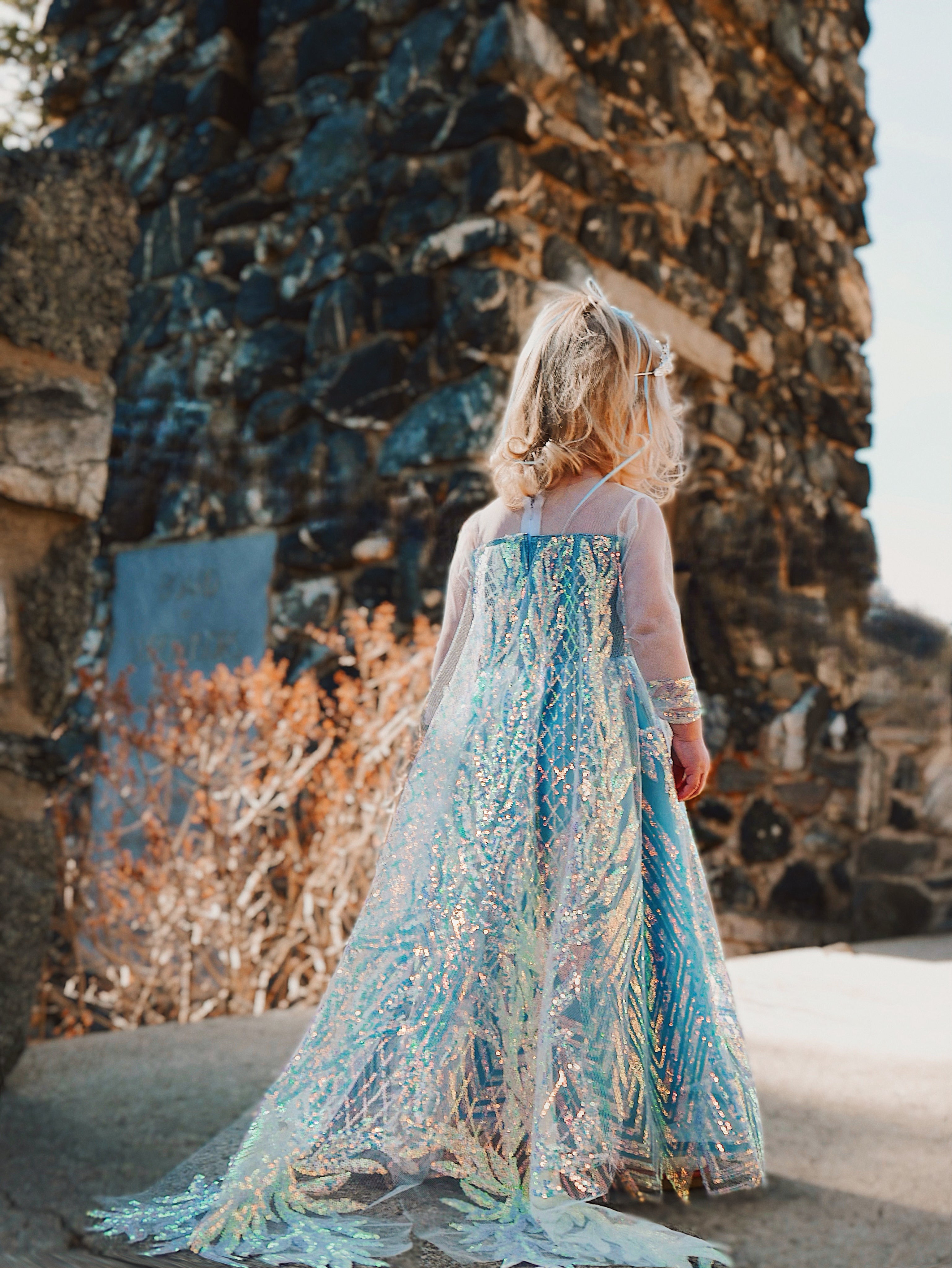 A blonde girl wears an Elsa Snow Queen Princess Couture Dress with Train