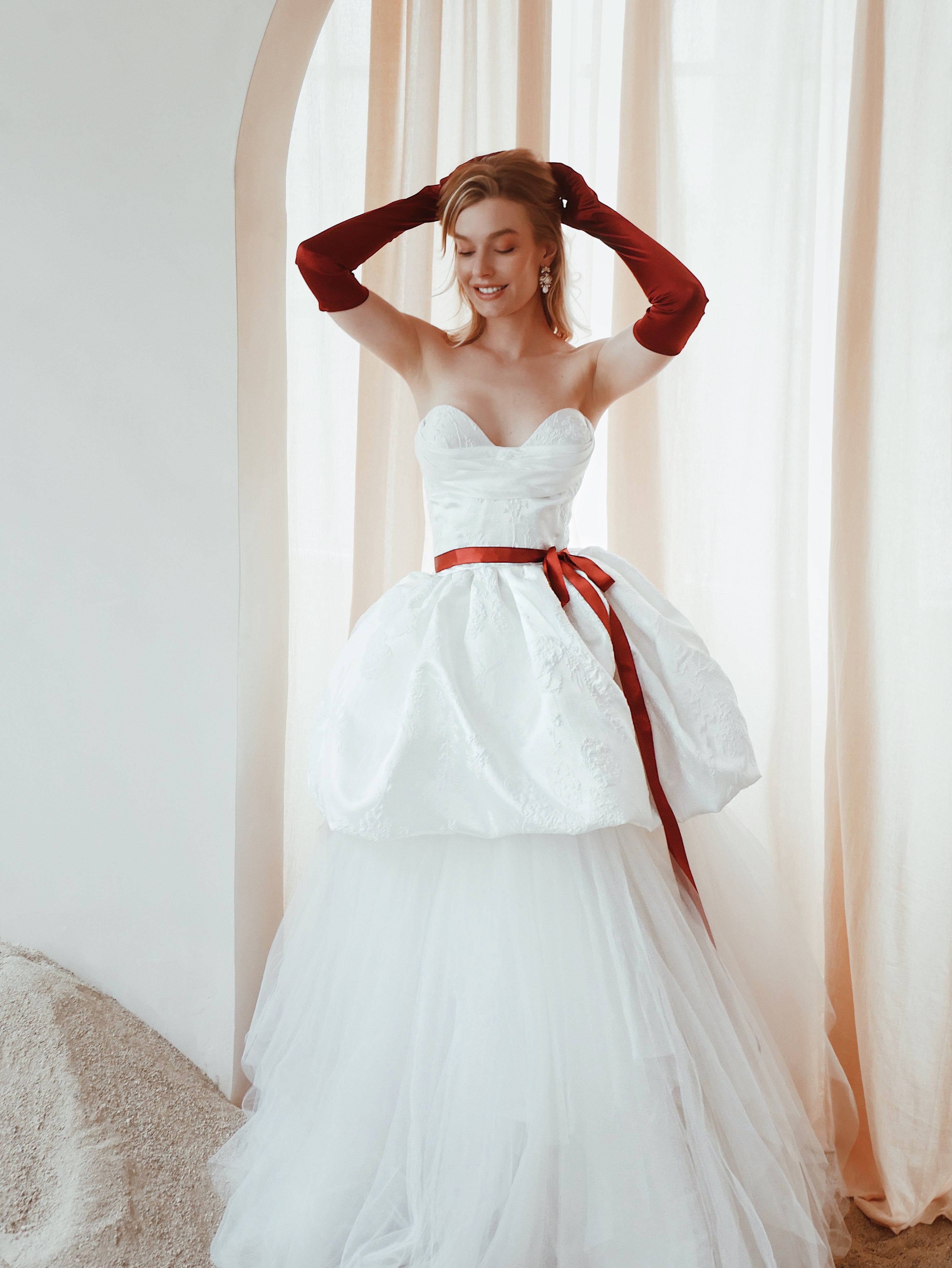 Full length image of a model wearing a tiered balloon hem wedding dress with crumb catcher corset.