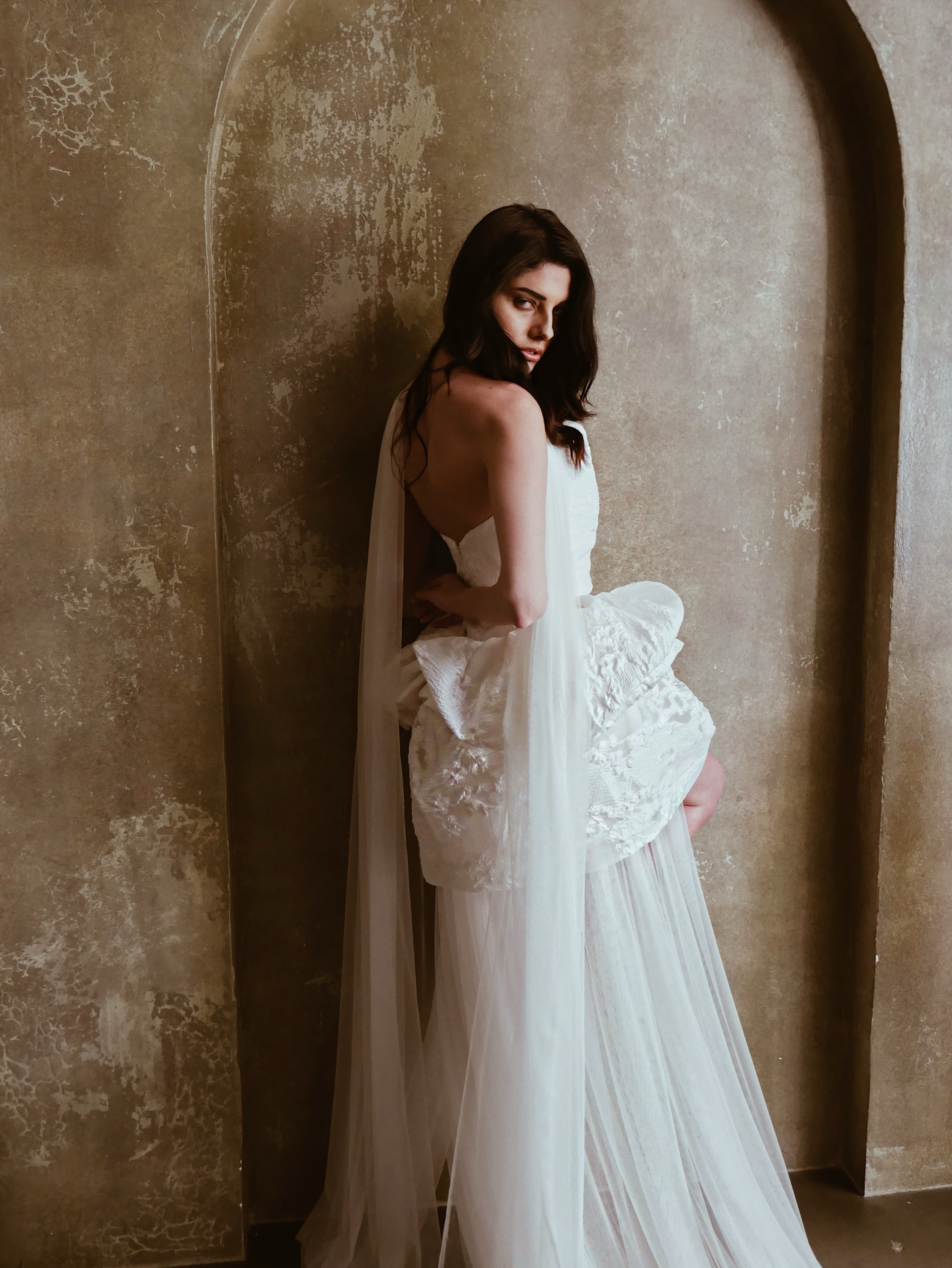 A model poses in an elegant and chic tulle nette bridal scarf veil.