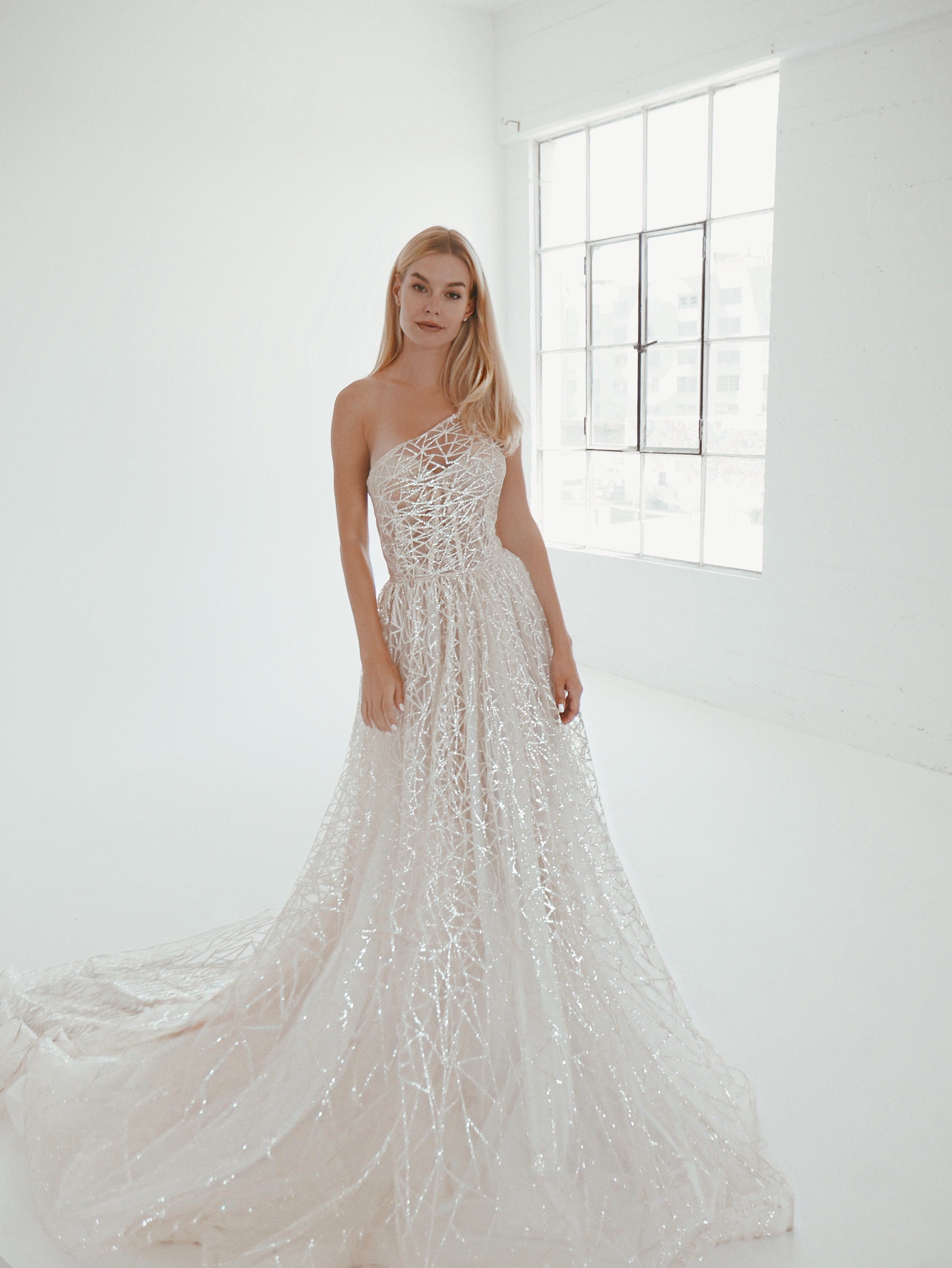 A models wears the a-line Prima wedding dress by Lauren Elaine with one shoulder corset.