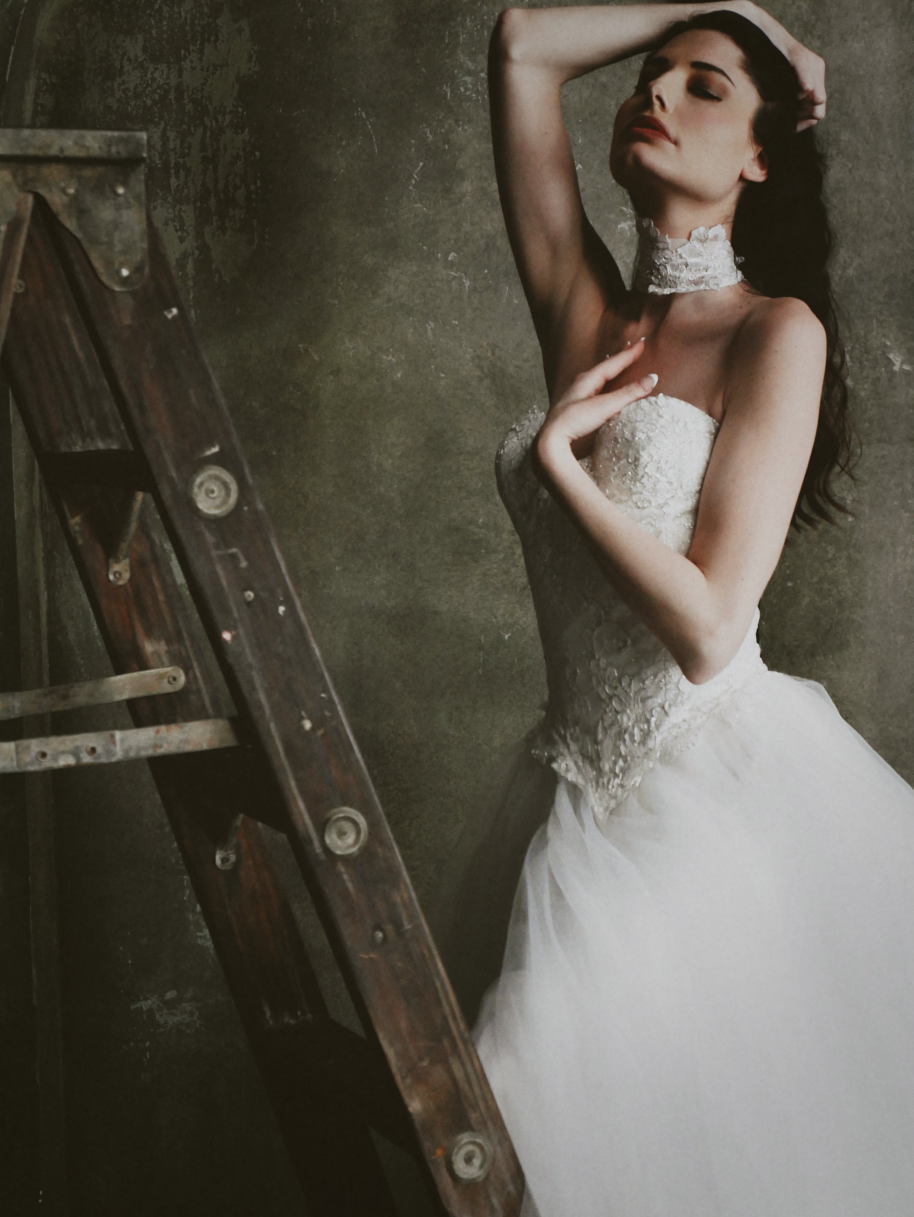 Wide shot of a model posing on a ladder in a photo studio Chantilly Lace Bridal Choker by Lauren Elaine.