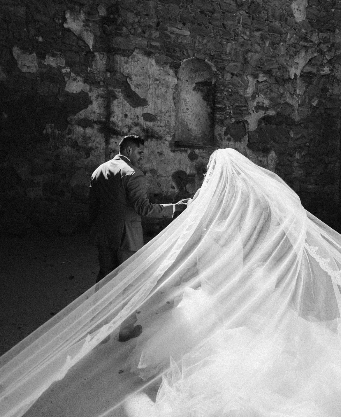 A bride wears a classic tulle wedding veil with lace trim by Lauren Elaine Bridal