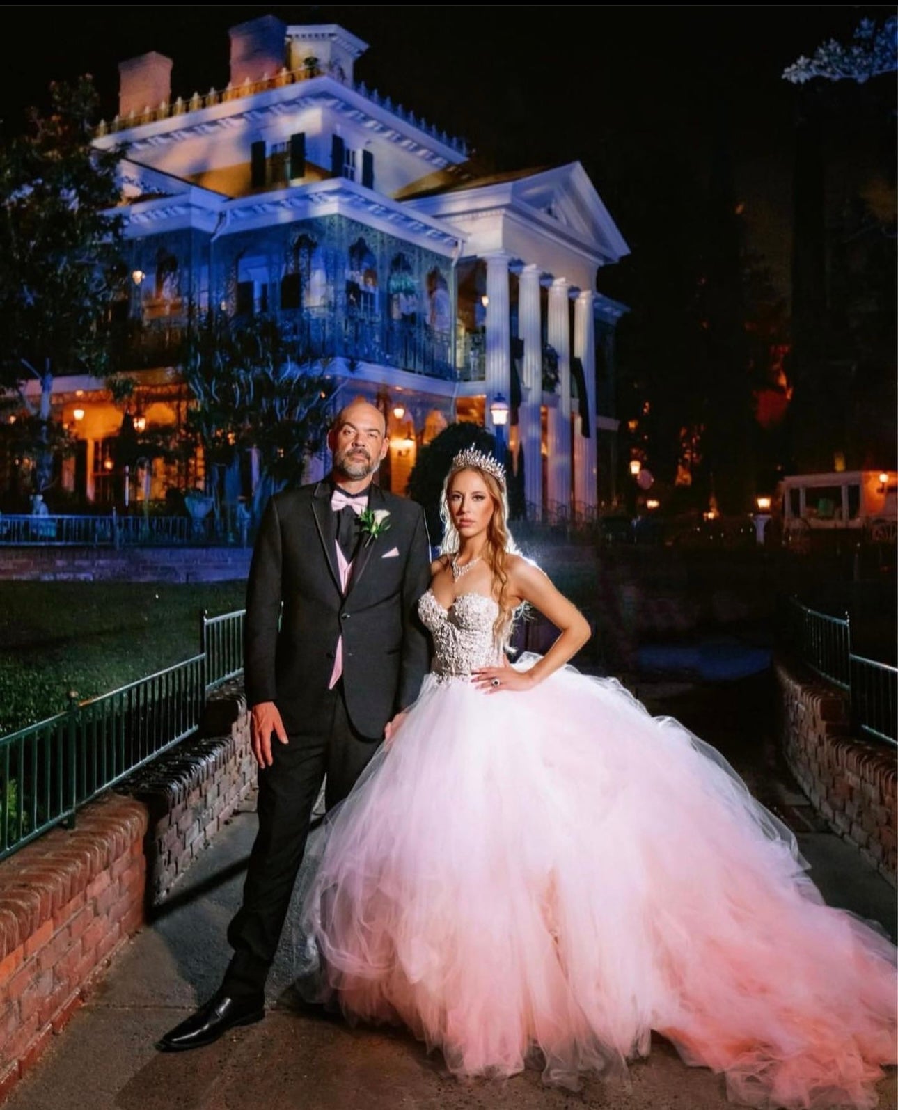 Bride Victoria wears a custom pink wedding dress by Lauren Elaine for her wedding at Disneyland's Haunted Mansion.