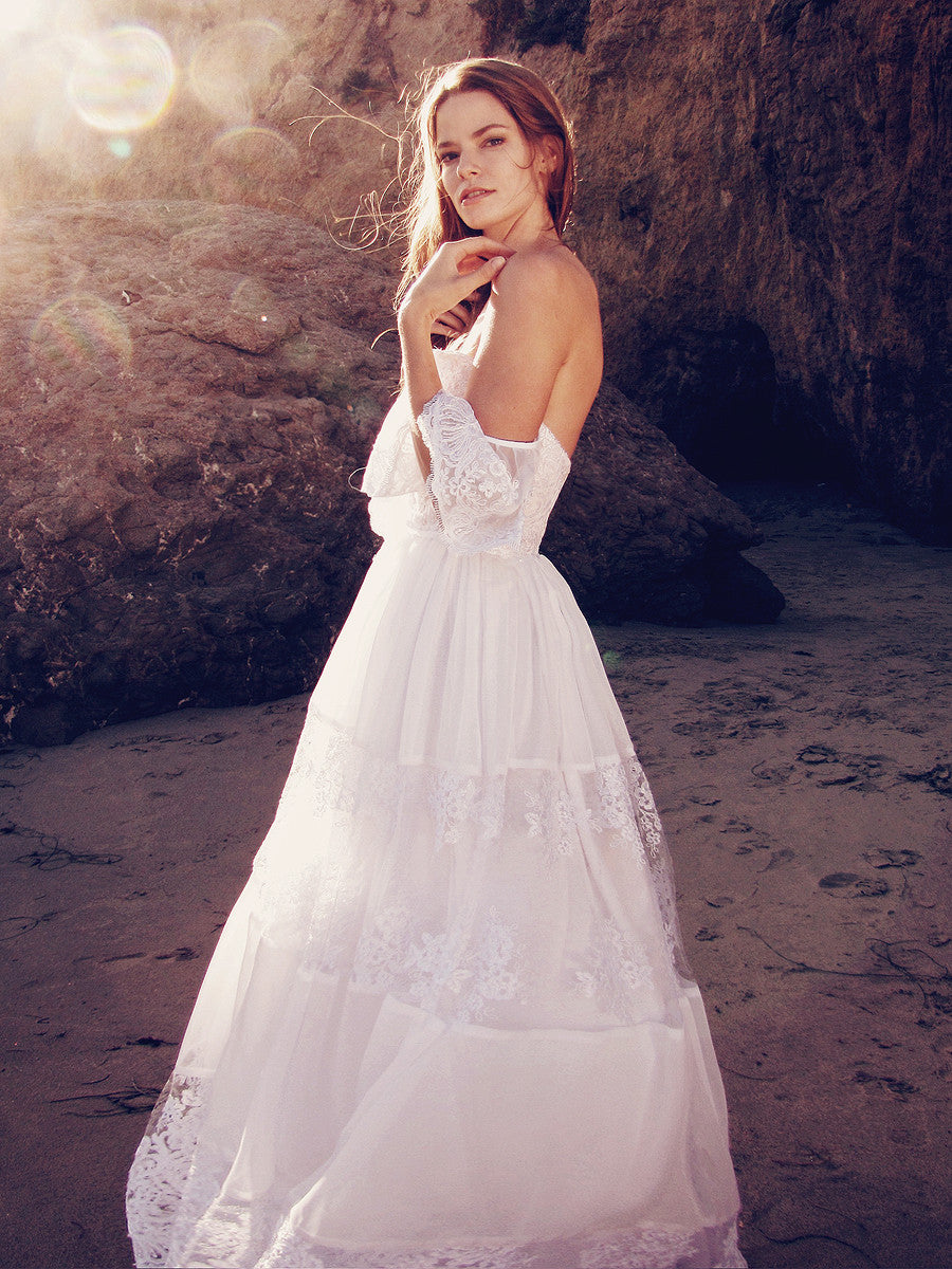 Off-the-shoulder lace bridal gown with tiered lace ruffled skirt and ruffle sleeves.