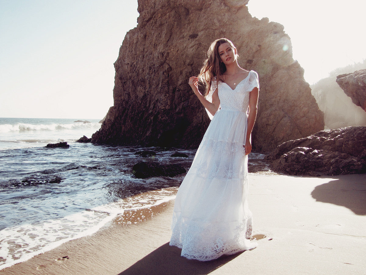 A-line lace wedding gown with tiered ruffle skirt and off-the-shoulder lace butterfly sleeves.