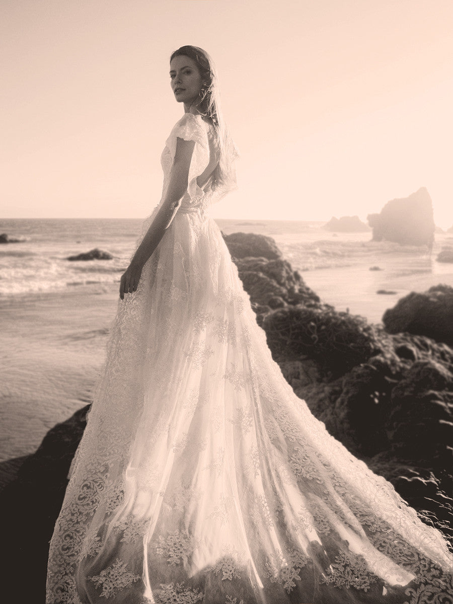 Boho lace and chiffon wedding gown with detachable train for beach weddings.