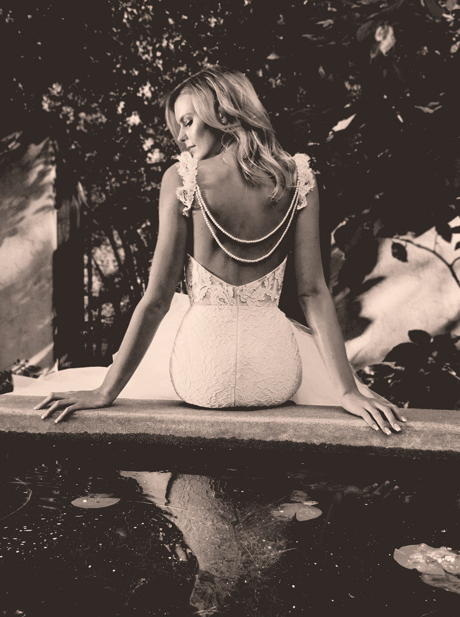 Backless mermaid wedding gown with draped pearls.