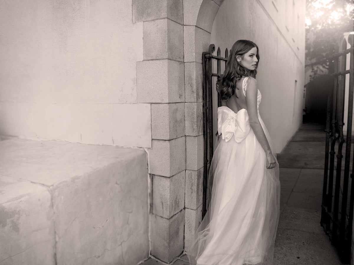 Open back lace wedding gown with bow. Made in the USA.