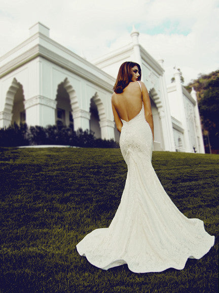 Backless lace wedding gown with satin-covered buttons. Open back bridal gowns