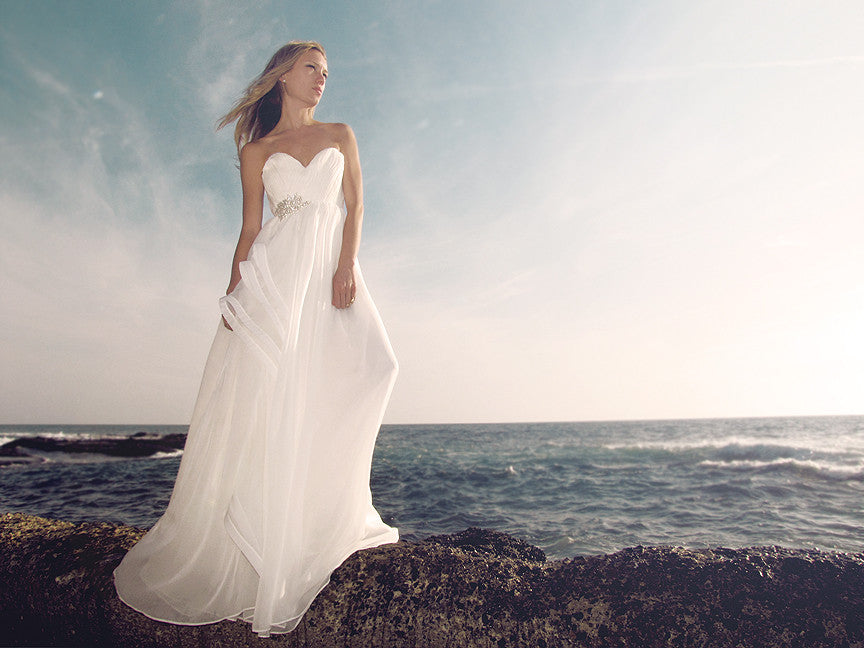 Cascading A-line chiffon gown with ruched sweetheart bodice, horsehair petal detailing, and Swarovski crystal embellishment. Made in the USA. Bohemian Bridal.
