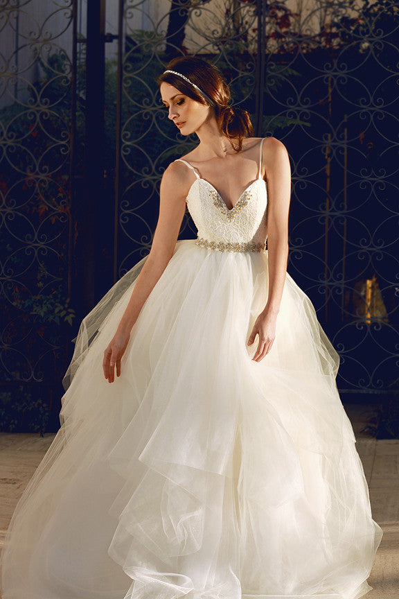A model poses in a Lace Sweetheart Backless Wedding Dress with crystal detailing.