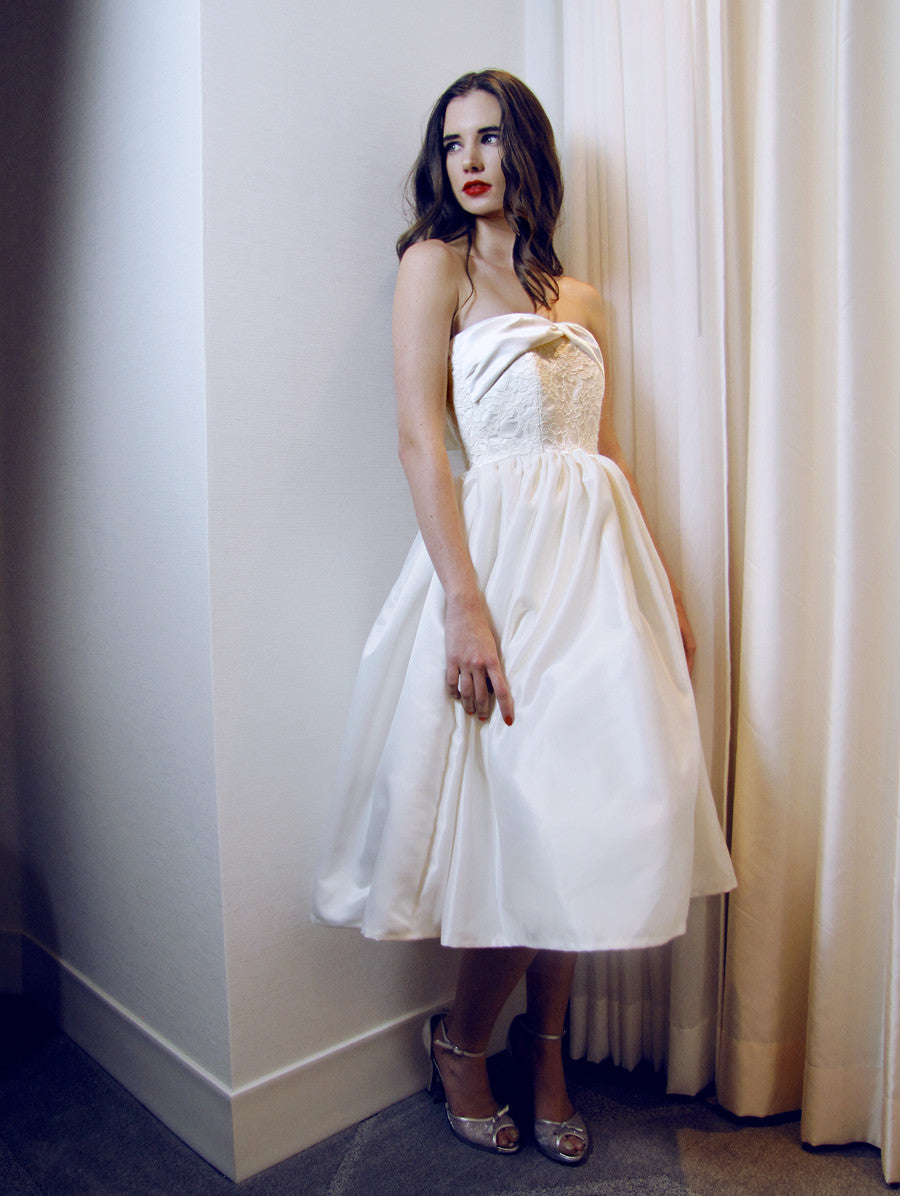 Tea-length vintage 1950's silhouette lace and satin wedding gown with ruching.