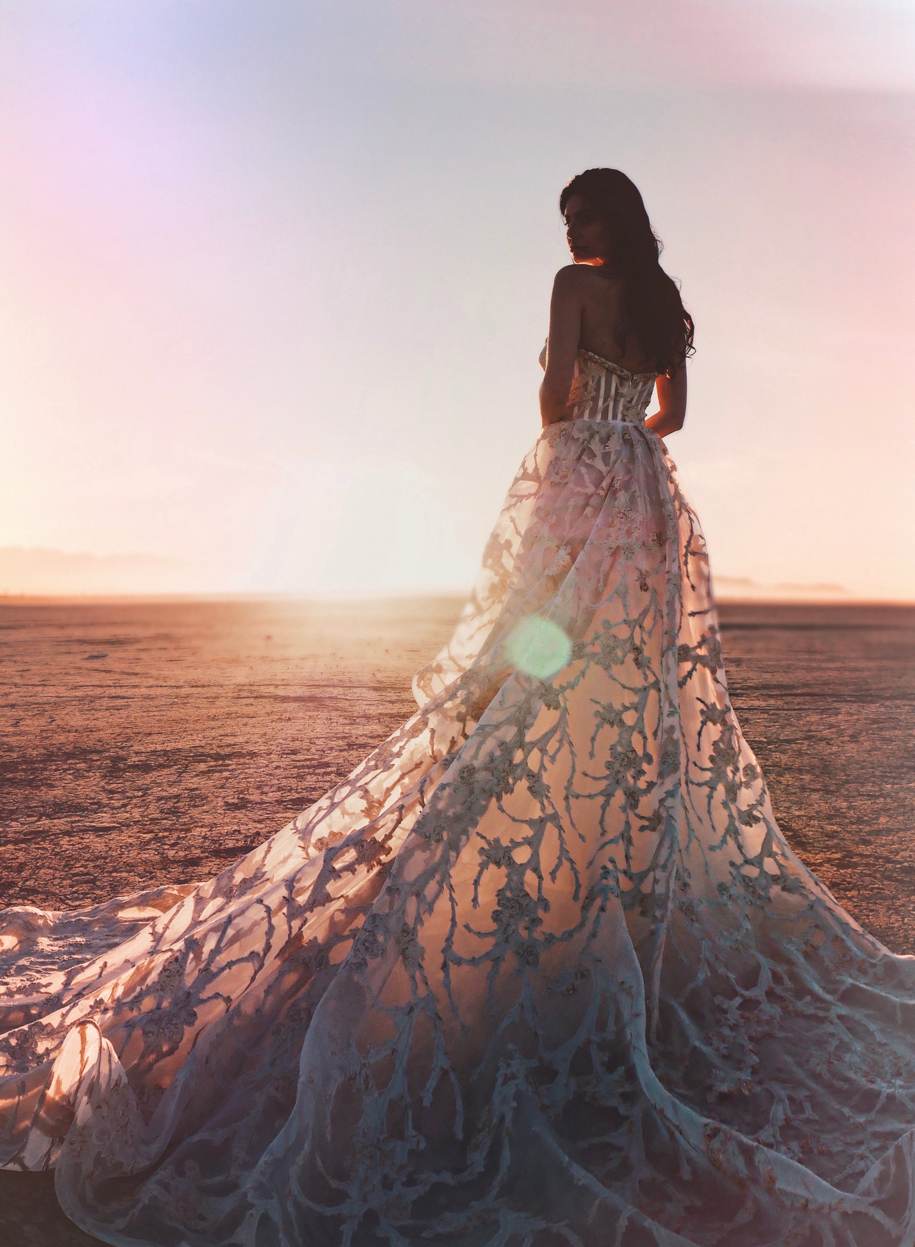 Gold bustier dress with long train at sunset
