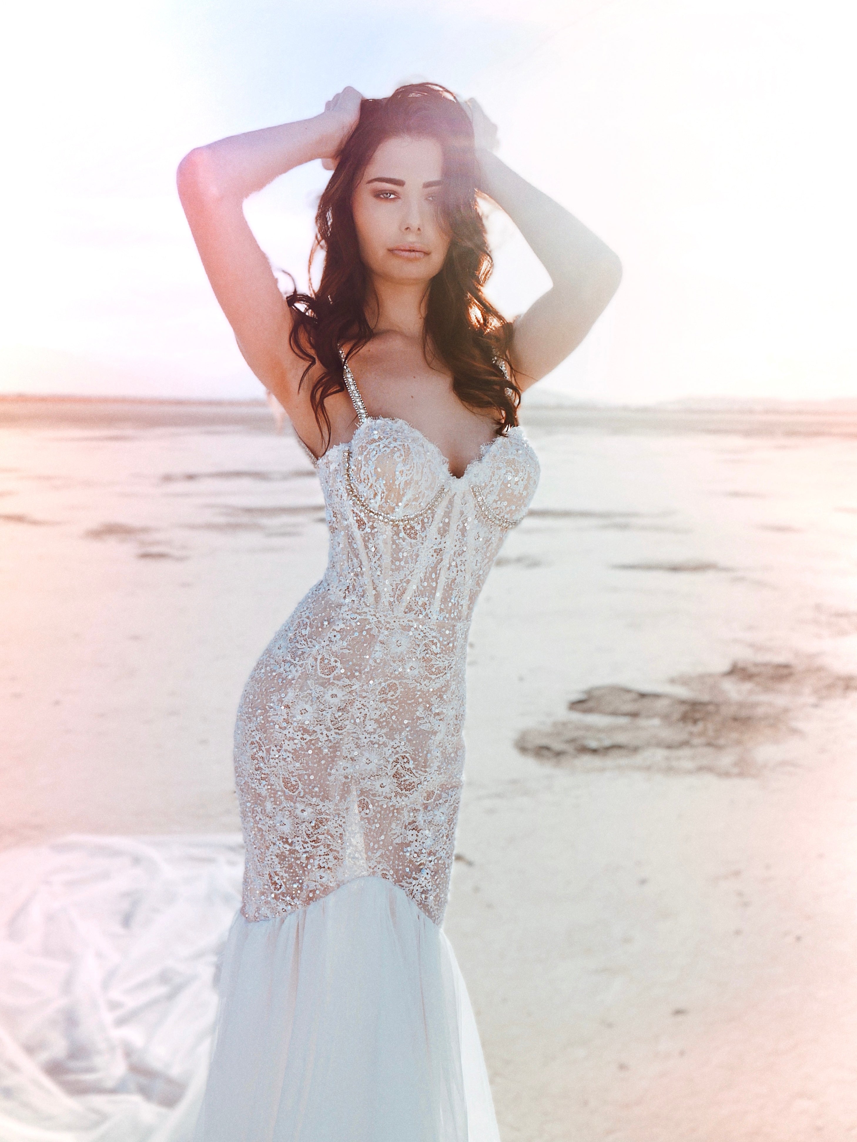 Lace corset mermaid wedding dress on model with hands on head