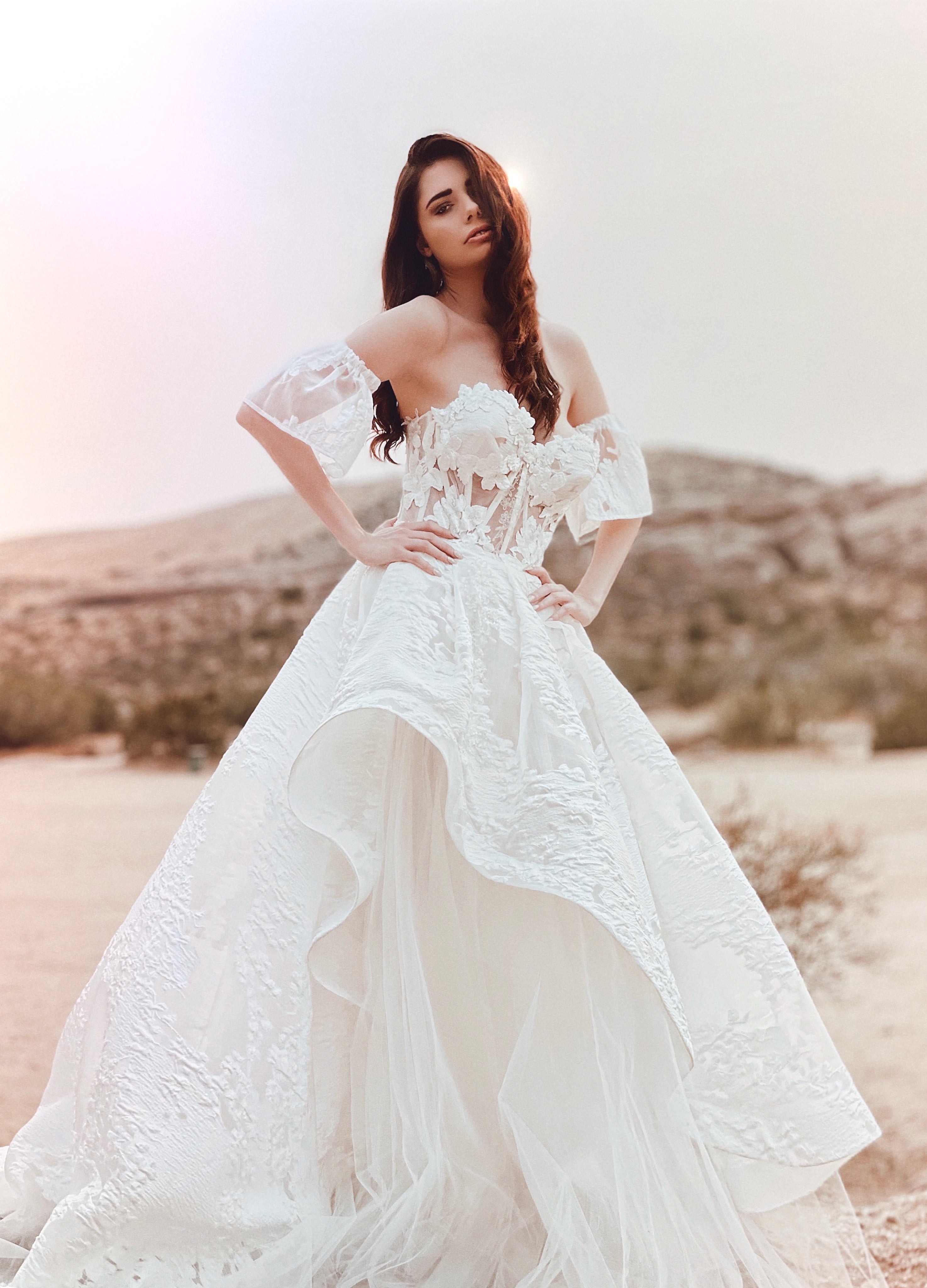 Front view of a model wearing a brocade floral organza corset wedding gown.