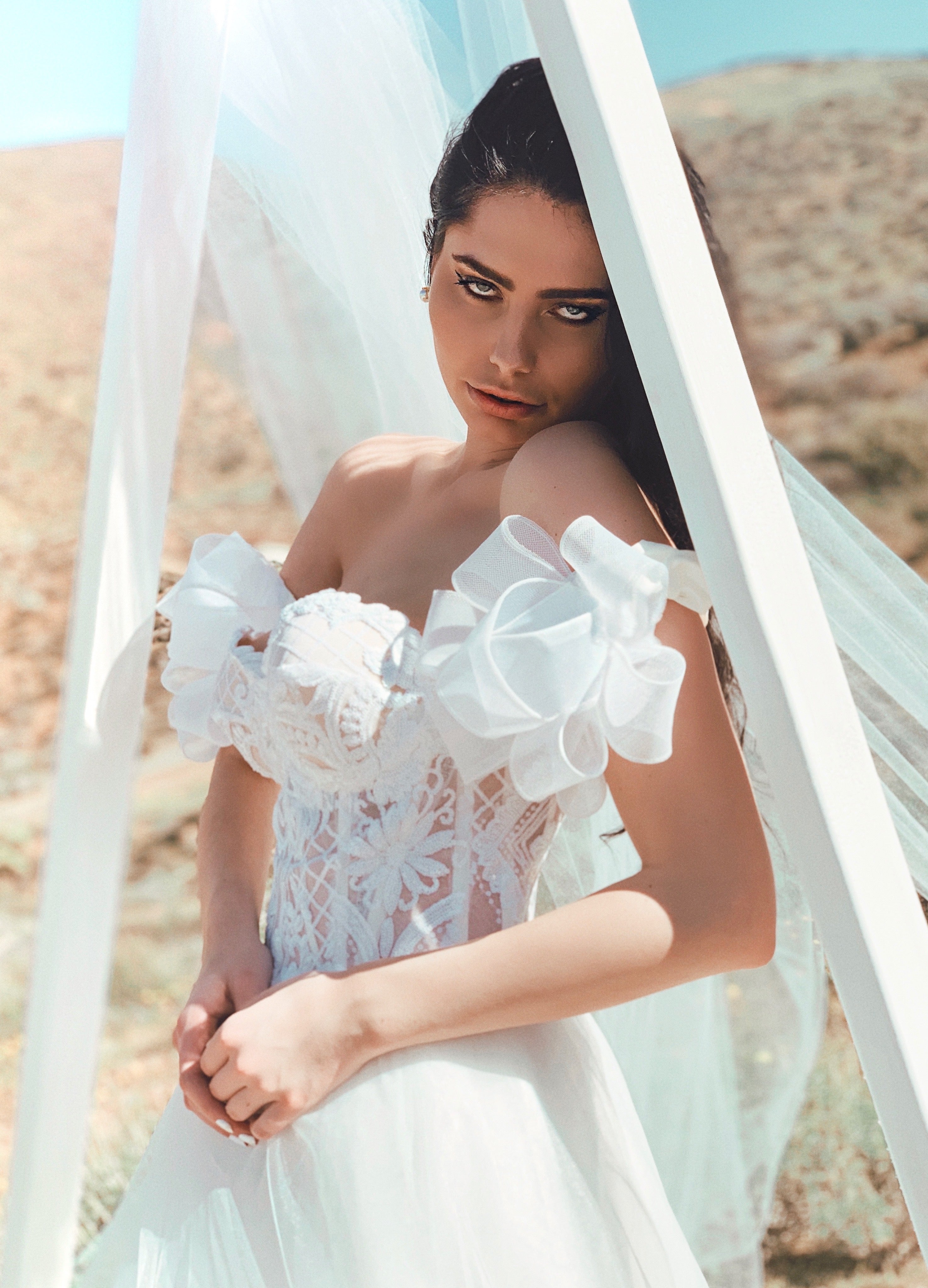 Closeup of sparkly corset wedding dress with detachable sleeves under wedding arch