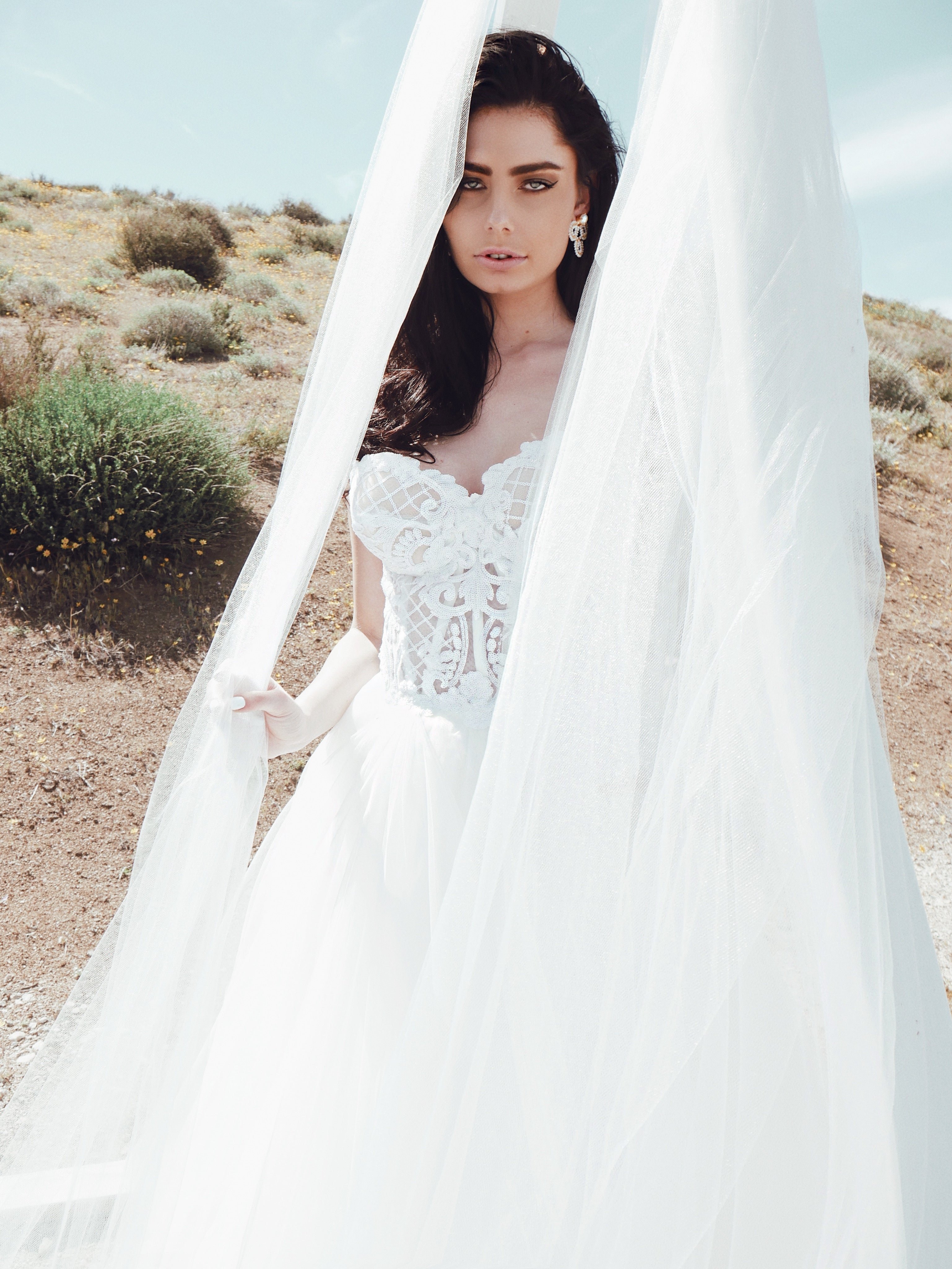 White sequin wedding gown bodice under tulle arch