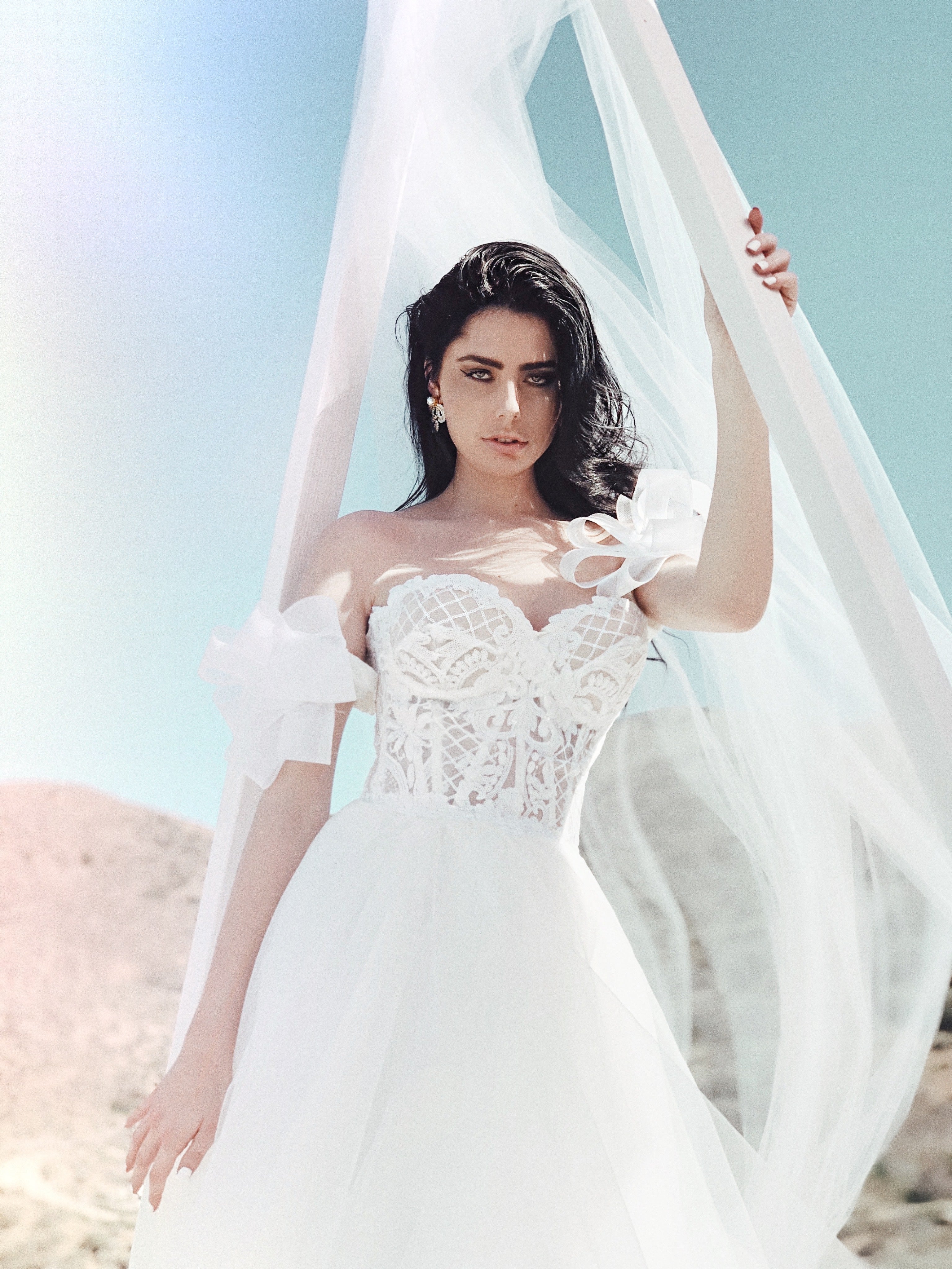 Closeup shot of floral bodice wedding dress with tulle skirt under wedding arch