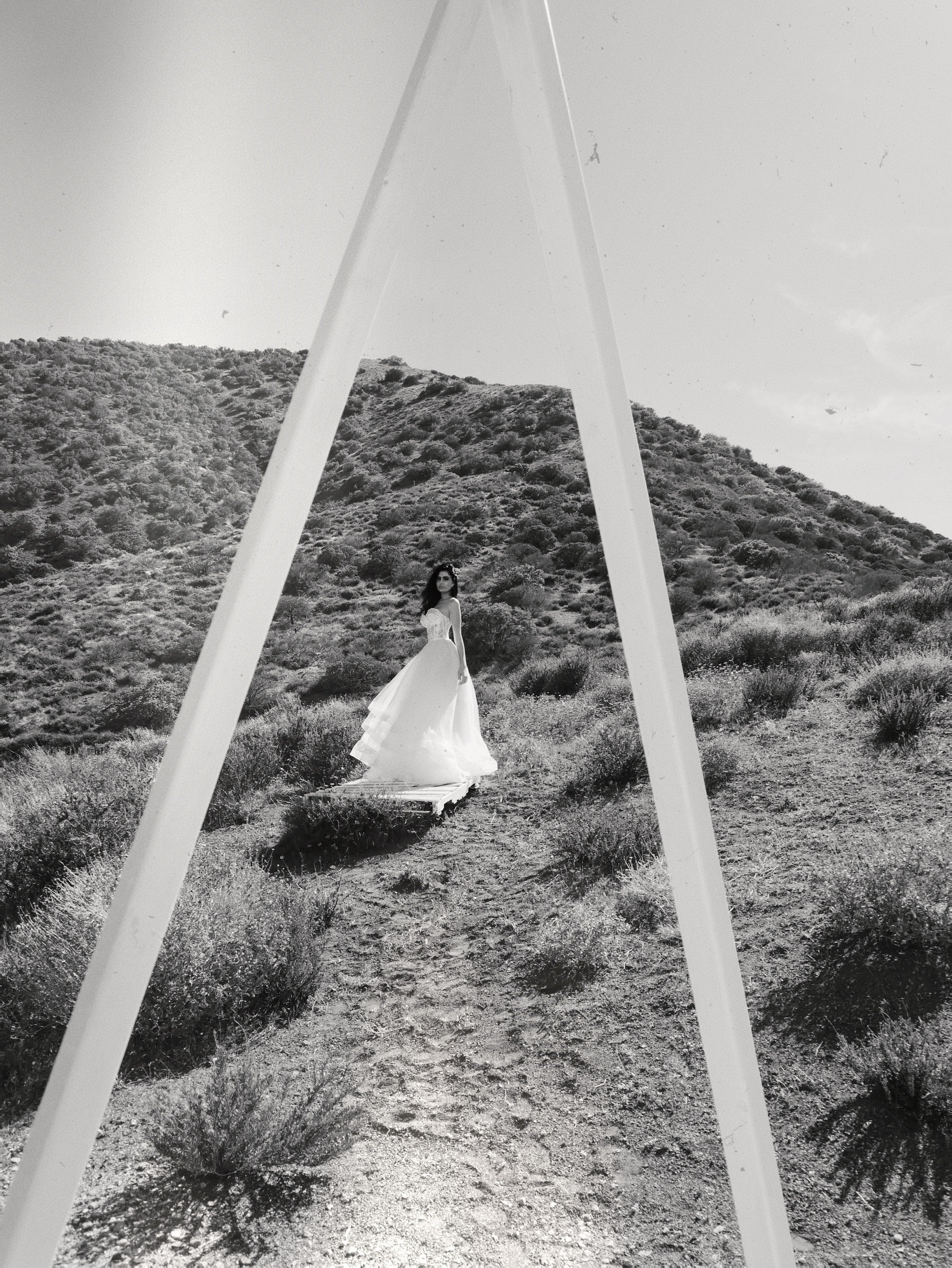 Black and white shot of a line wedding dress tulle skirt in desert field