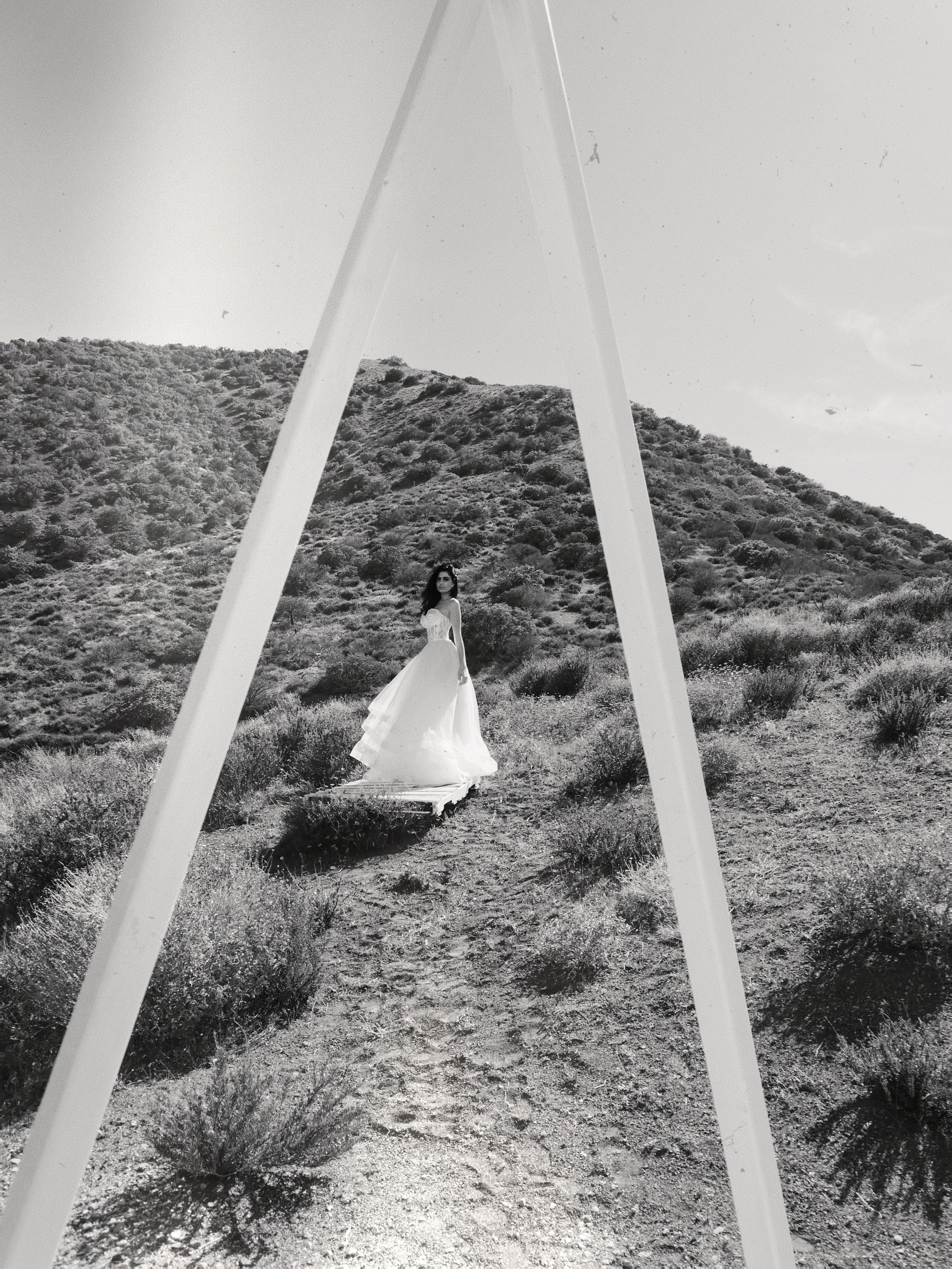 Black and white shot of  a line wedding dress tulle skirt in desert field