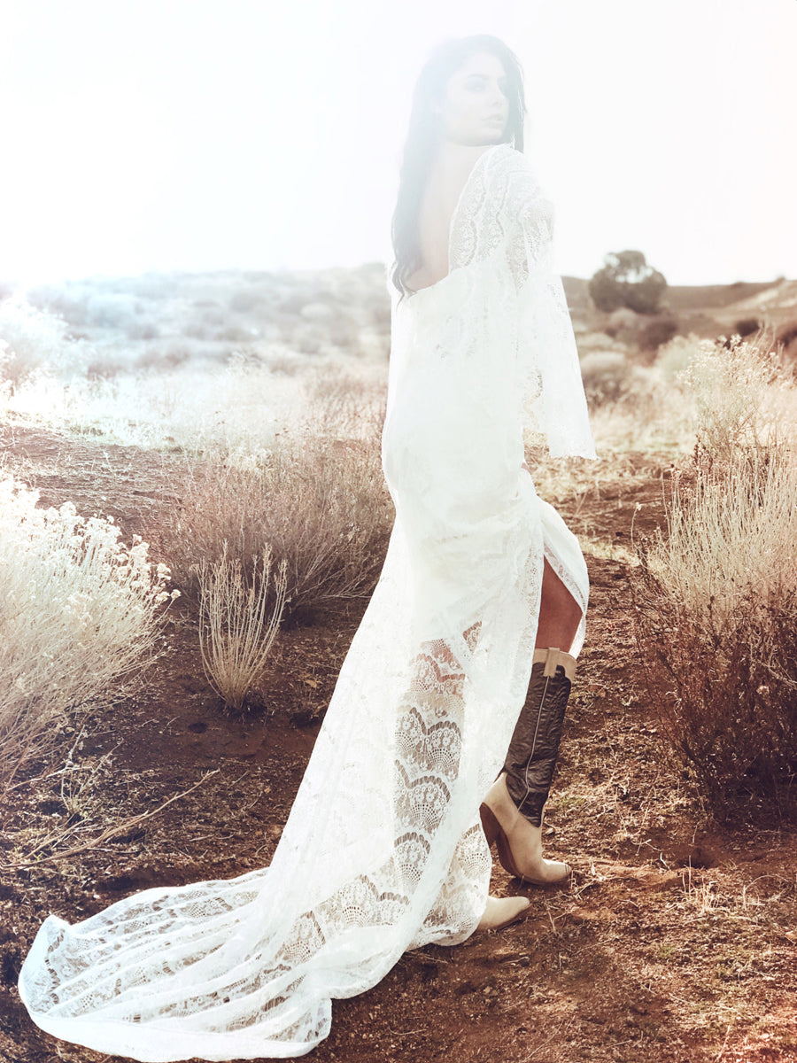 Vintage feel bohemian sheath wedding dress with lace cape sleeves.