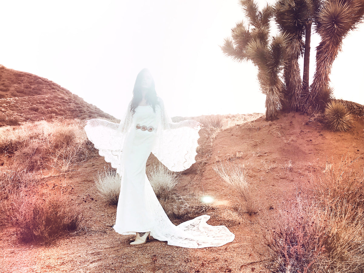 Bohemian lace wedding dress with lace angel wing cape sleeves and chapel length train. Larkin by Lauren Elaine Bridal.