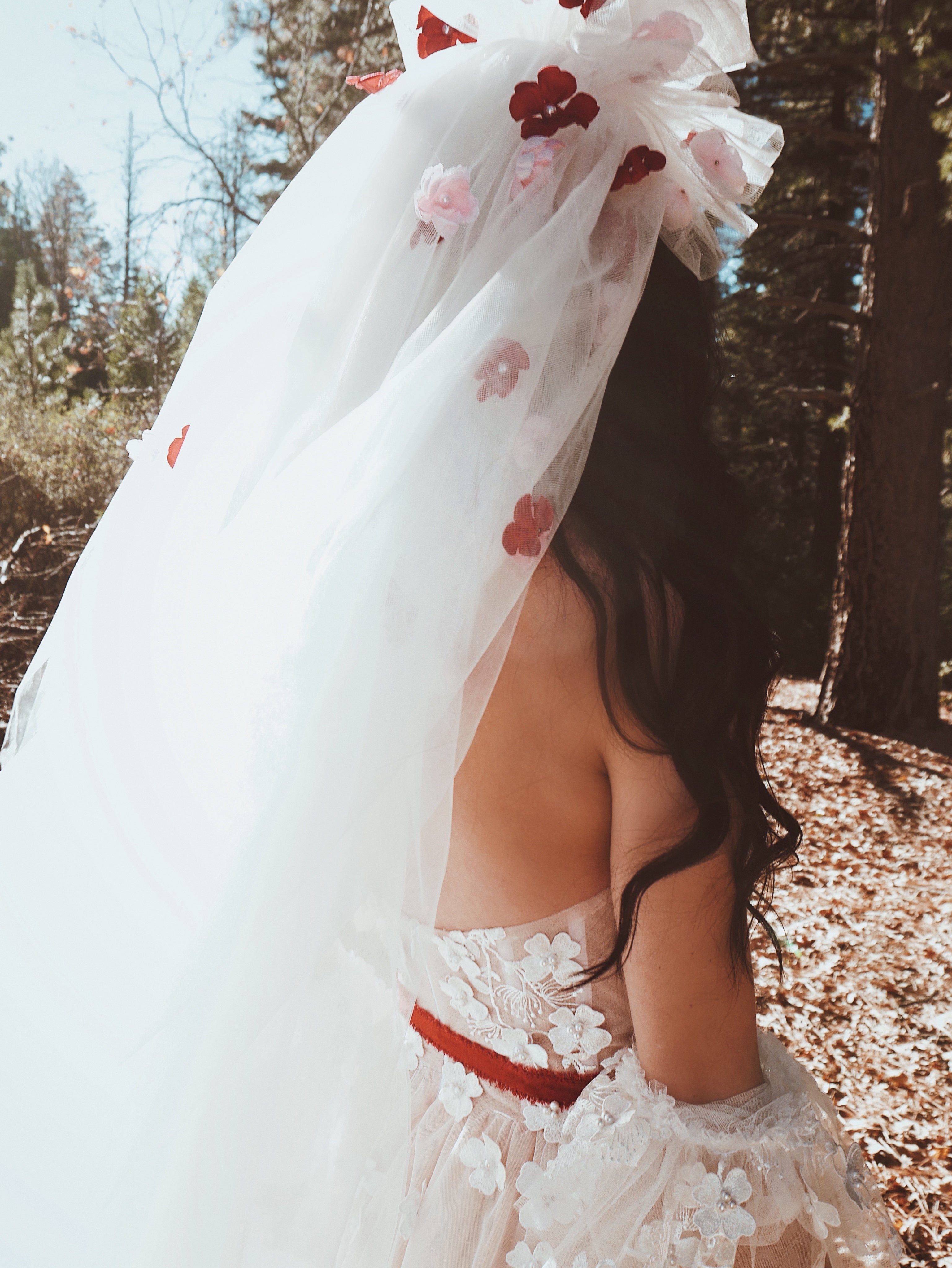 Bride in forest setting wearing the CHÉRIE dramatic 1980s tulle veil with floral details by Lauren Elaine.