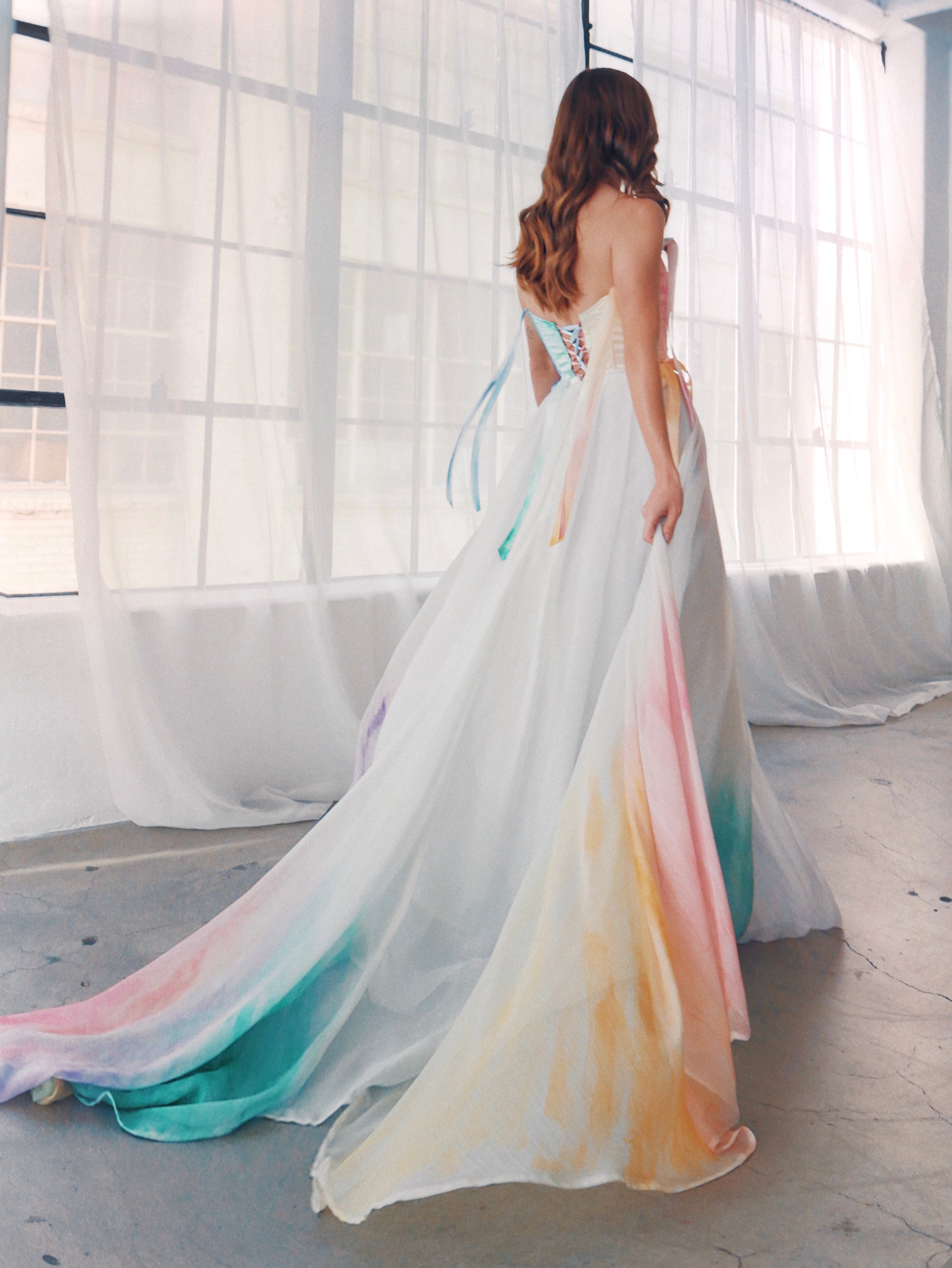 Ethereal watercolor bridal gown with pastel ombré chiffon layers and lace-up back, romantic modern bridal style