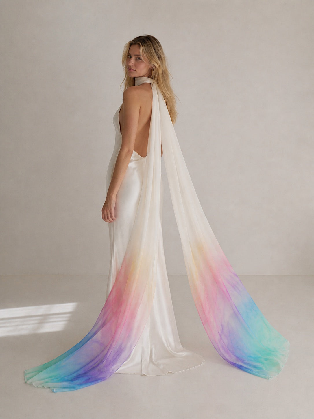 Bride wearing Chroma watercolor bridal neck scarf in pastel rainbow ombré chiffon with open-back satin wedding gown