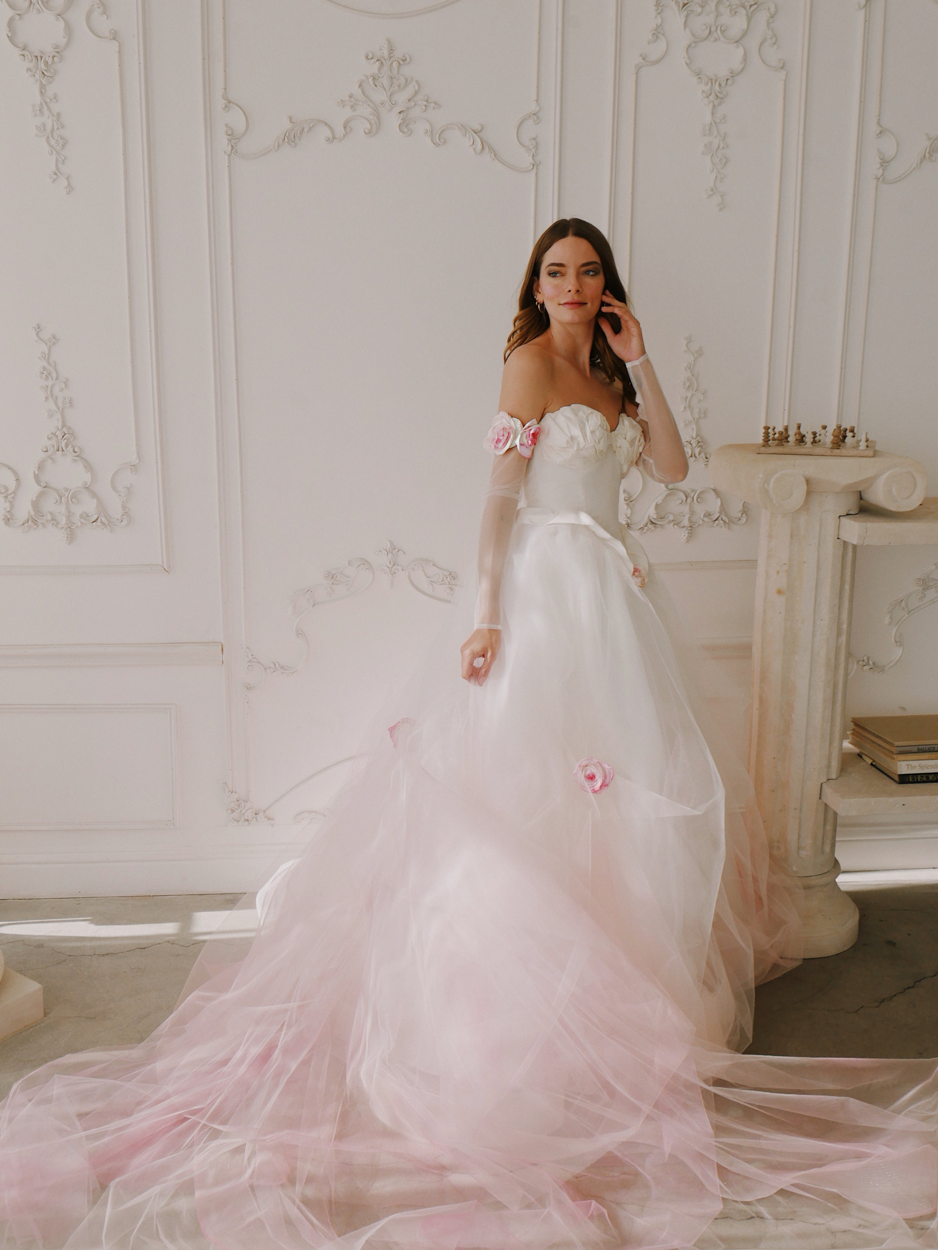A model poses in a Romantic Blush ombre pink Wedding Dress with Hand Painted Rosettes 