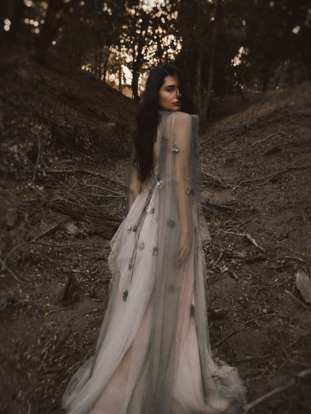 Back view of Florêve Midnight ethereal wedding dress with gray sheer tulle cape and dark floral appliqués