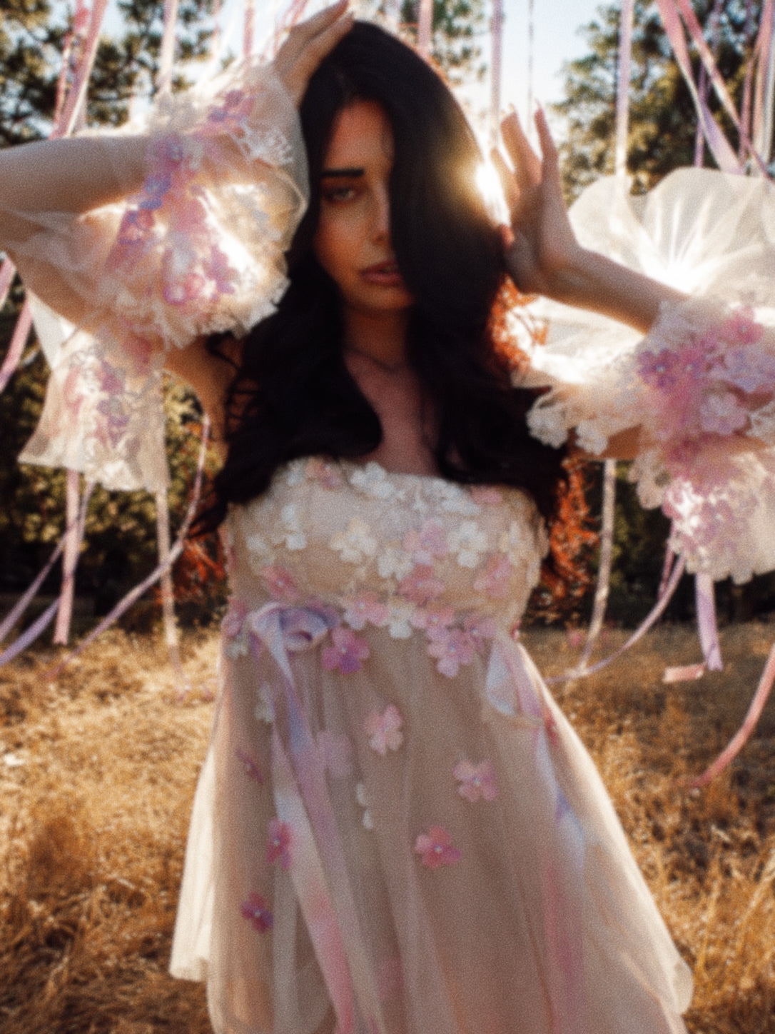 Close-up of Florêve 3D floral wedding dress with hand-painted pink and lavender wildflowers and sheer floral sleeves